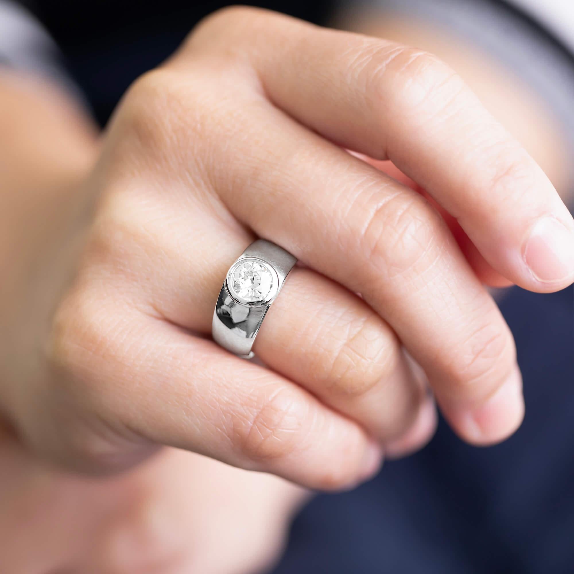 This is a stunning statement diamond ring. It features an early European cut diamond, bezel set in a wide half round 18k white gold band. A classic, beautiful ring that will complement any collection.

Diamond: One early European cut, K-M colour,