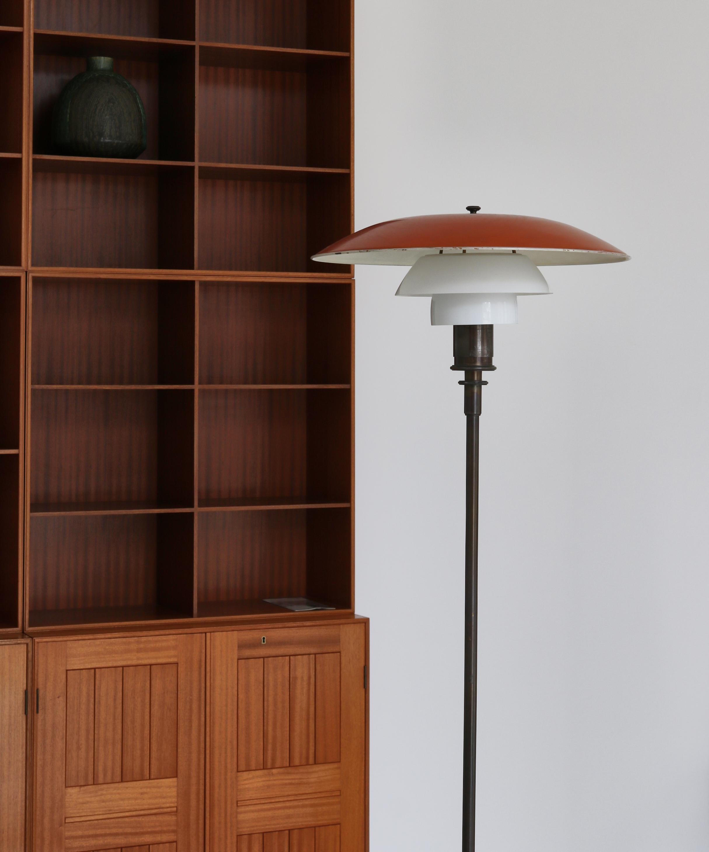 Early and important floor PH-lamp 4/3 by Poul Henningsen (PH) manufactured at Louis Poulsen, Copenhagen between 1926-28. The lamp base is made from patinated bronze and the top shade is red and white lacquered bronze. Middle and lower screen are