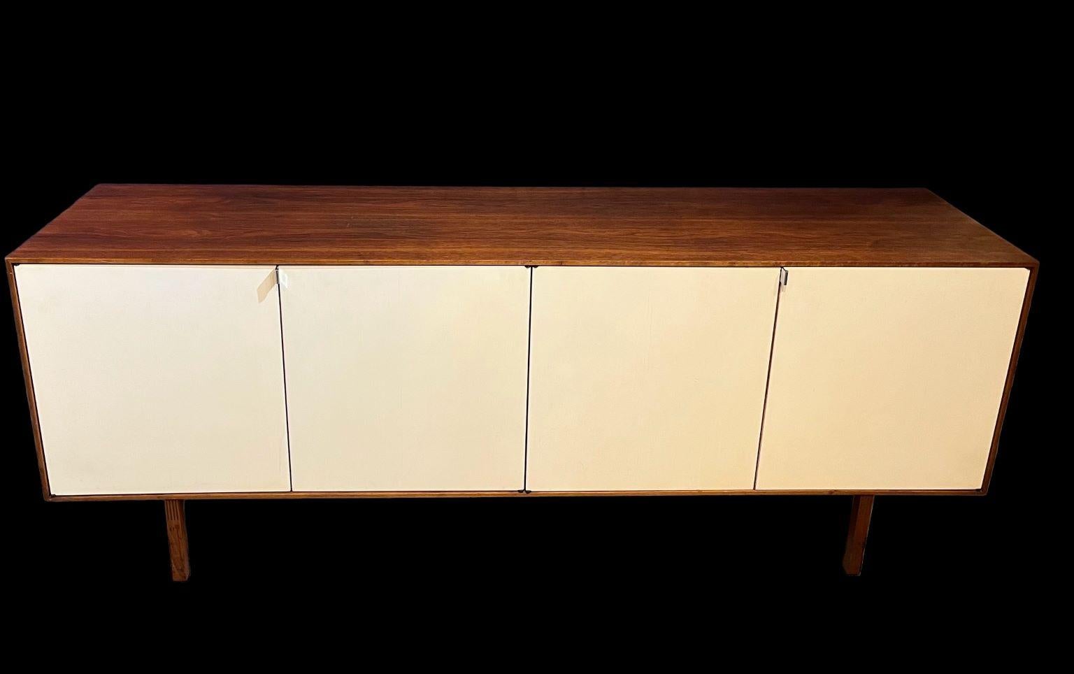 Exceptional early Florence Knoll for Knoll Associates Credenza. Beautiful walnut veneer cabinet with white lacquer doors and maple veneer inside. Cabinet has an early Knoll tag on the bottom of cabinet. Dimensions 75.5 inches long by 28.5 inches