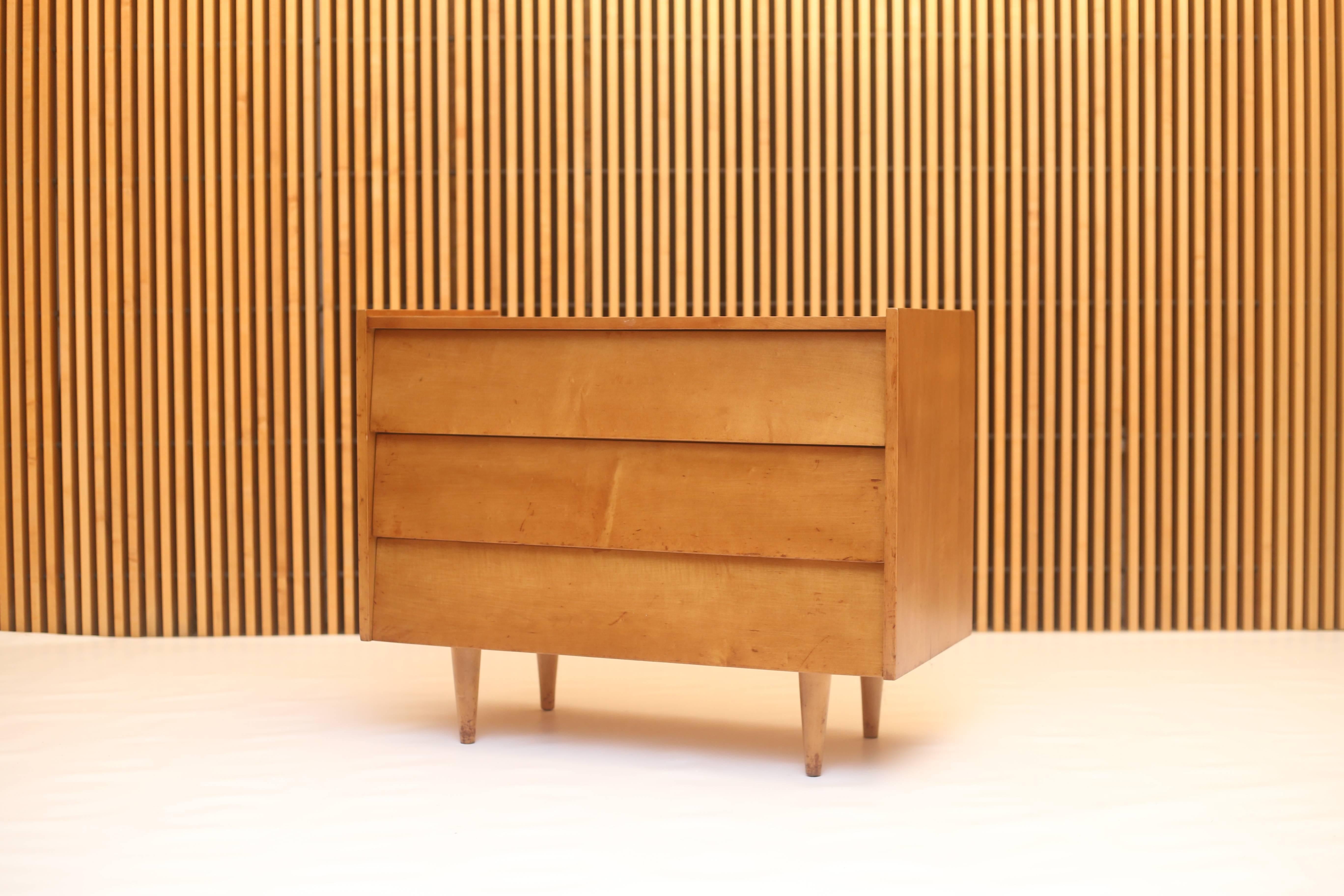 An early example retaining its 601 Madison Ave label dates this cabinet to the late 1940s. This small chest consists of three drawers with louvered fronts. The raised edges on the top is a rare configuration. Solid maple construction and was