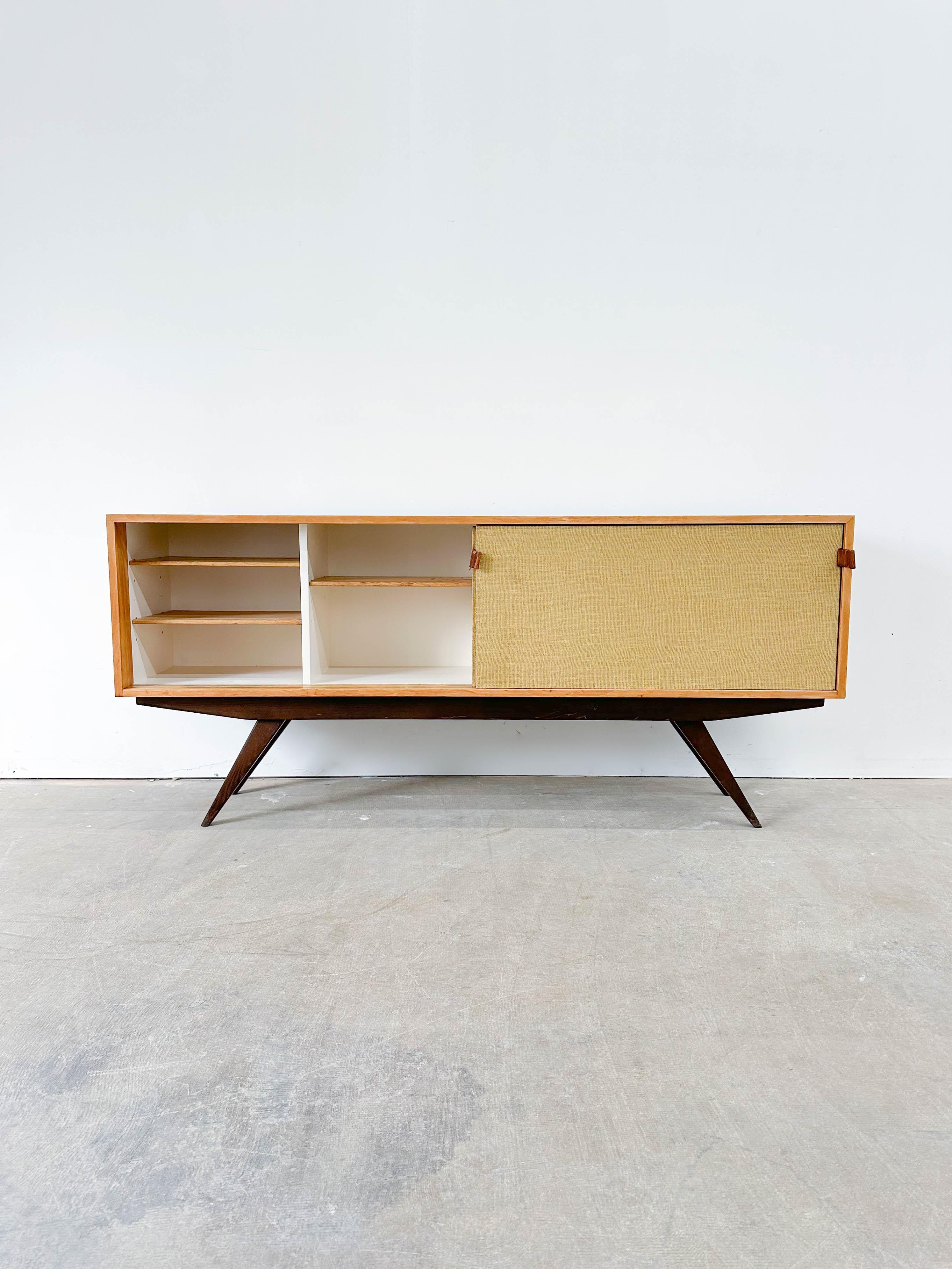 Early and rare credenza designed by Florence Knoll and produced by H.G. Knoll Associates from 1947-1949, predating the company's change to Knoll Associates. Featuring a birch plywood case, ebonized oak legs, white painted interior, three adjustable