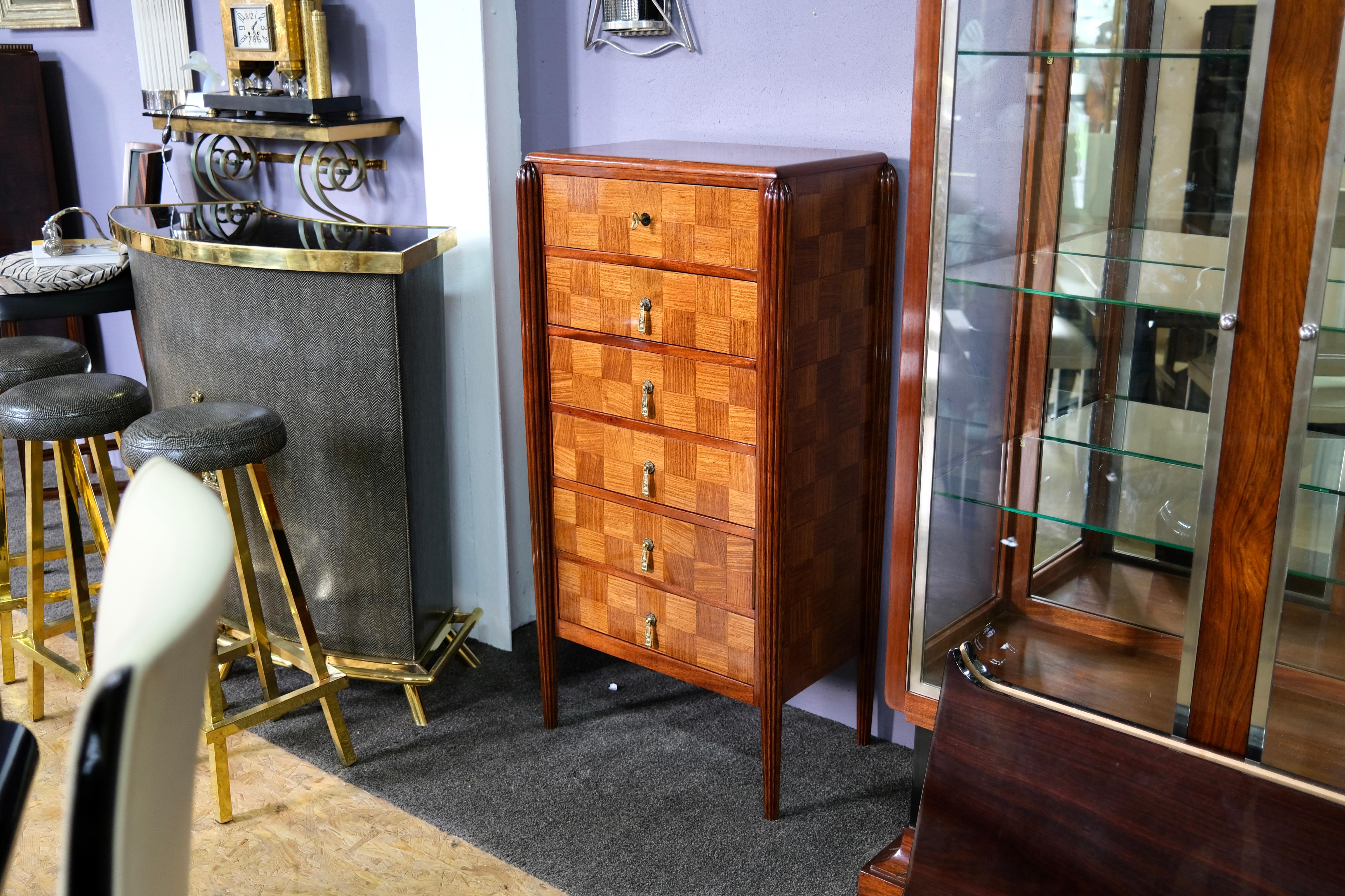 High chest of drawers
wooden body, hand polished shellac
probably stained ash and mahogany
fluted legs

Early Art Déco, France around 1925

Dimensions:
Width: 62 cm
Height: 122 cm
Depth: 40 cm