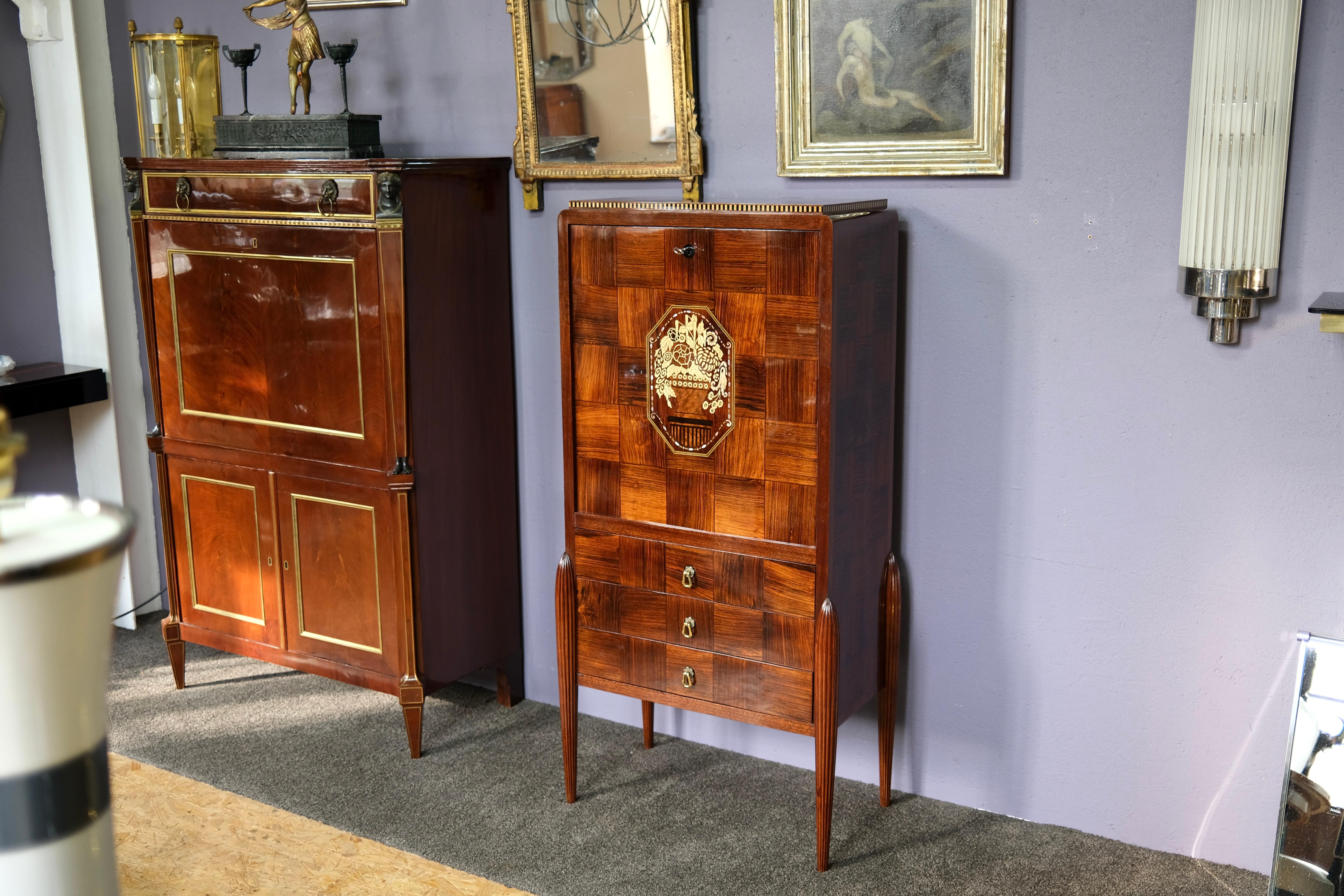 Secretary
Wooden body, hand-polished shellac
probably stained ash
elaborate inlays and marquetry 
freshly mirrored inside

Early Art Déco, France around 1925

Dimensions:
Width: 70 cm
Height: 140 cm
Depth: 40 cm
Body (without legs): 64.5 cm wide /