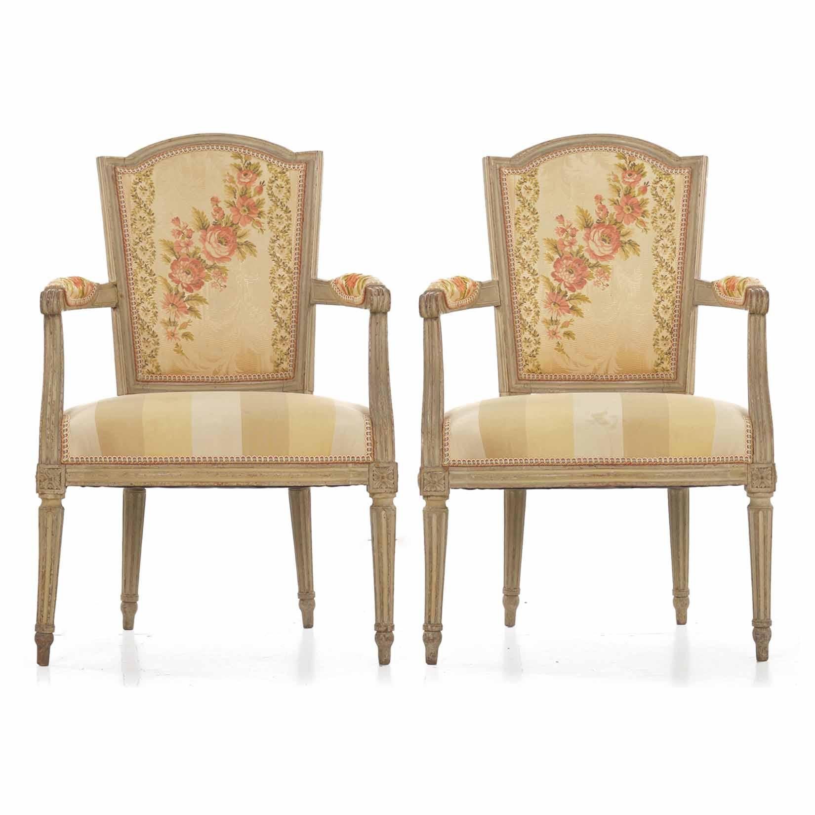 A fine pair of neoclassical beechwood fauteuils in early gray paint, they feature a trapezoidal chair back with an arched crest with double-pegged Tenon-mortised corners, open arms both upholstered with reeded handholds over cyma curved arm