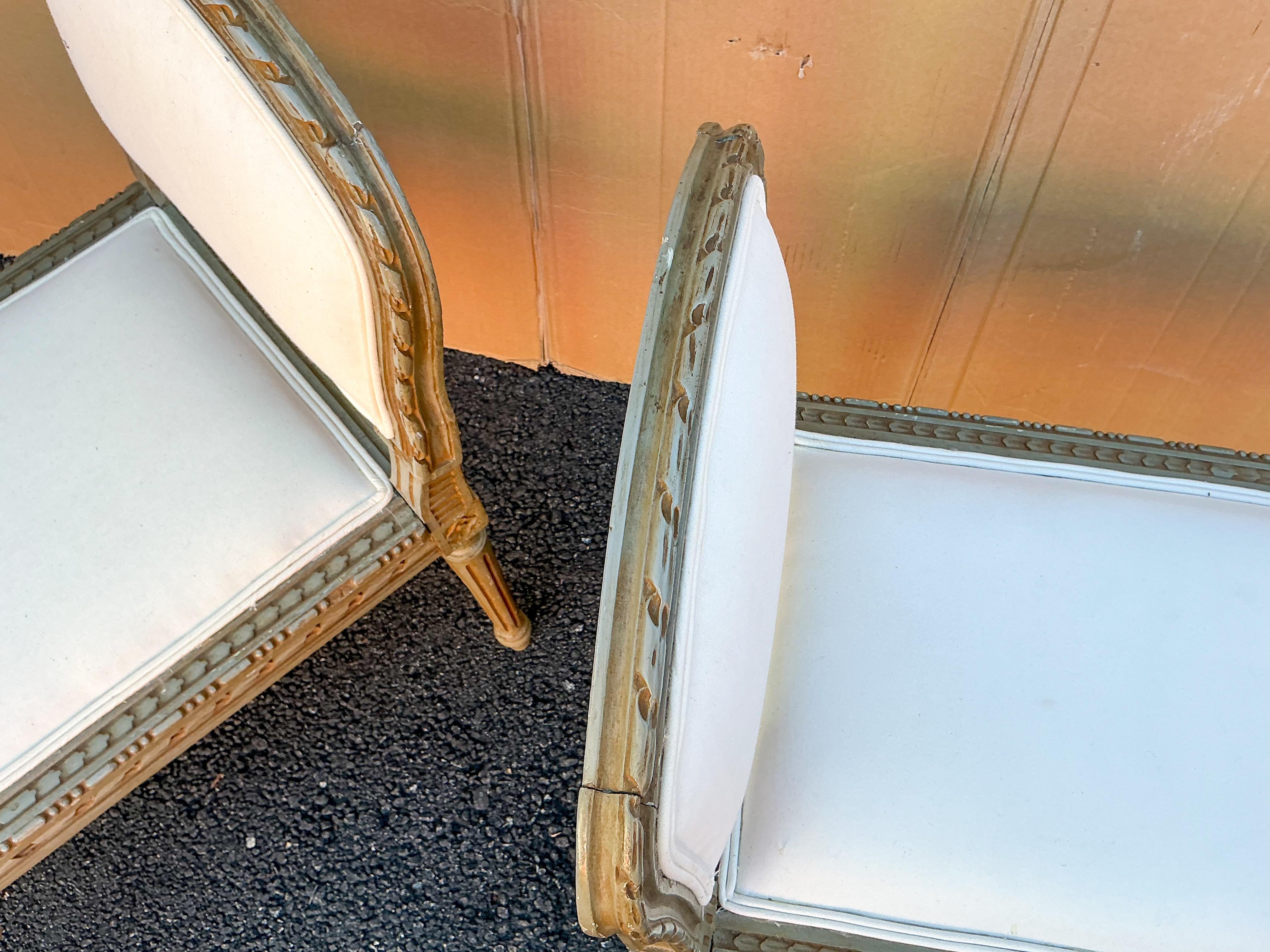This is a pair of early 20th century French Louis XVI style carved fruitwood benches upholstered in what appears to be a white cotton. The finish is unlikely to be original, see second photo for a clear depiction of the color. They are in very good