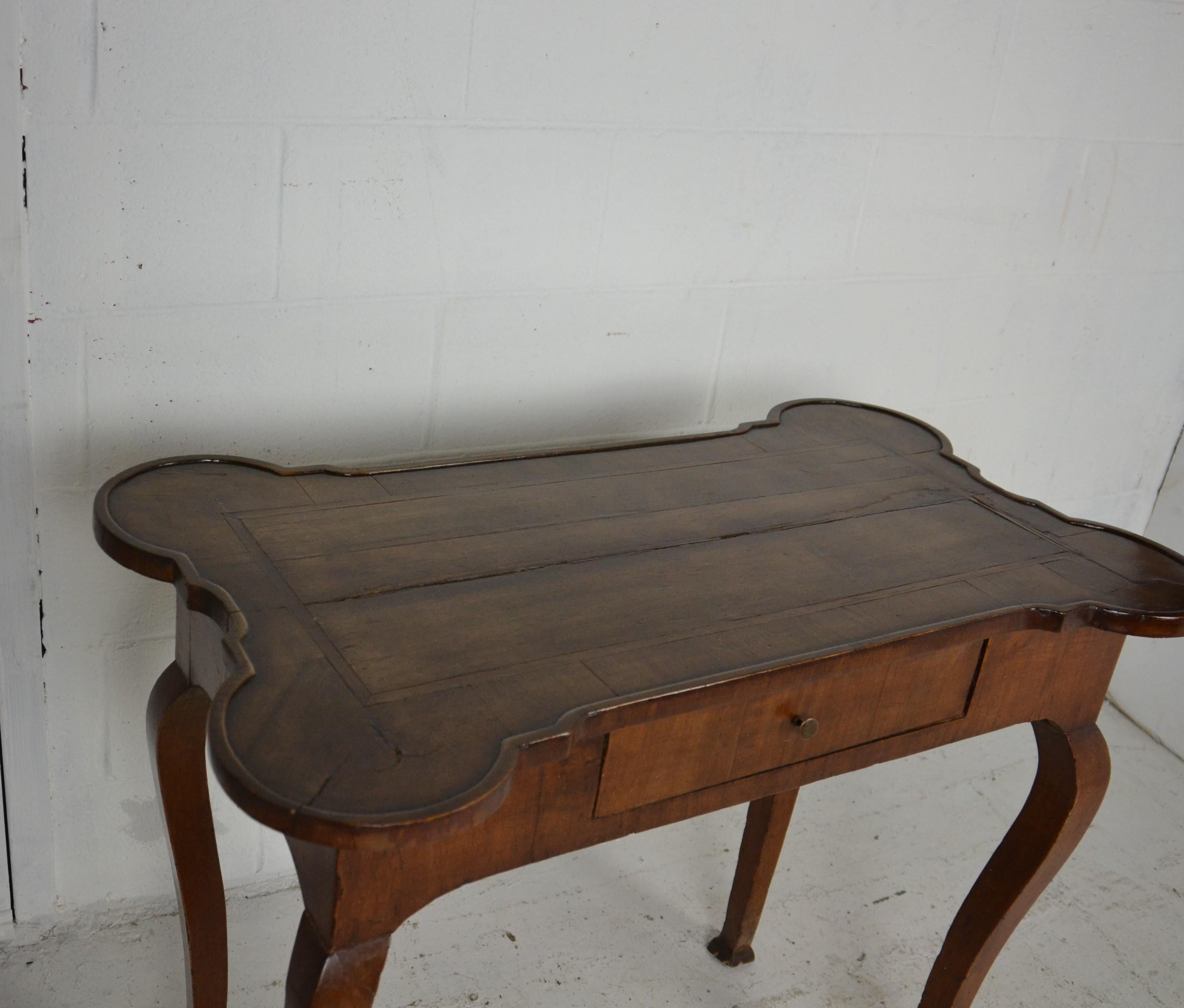 An early walnut side table with a nicely shaped top. Cabriole legs with worn pad feet, early 19th century.