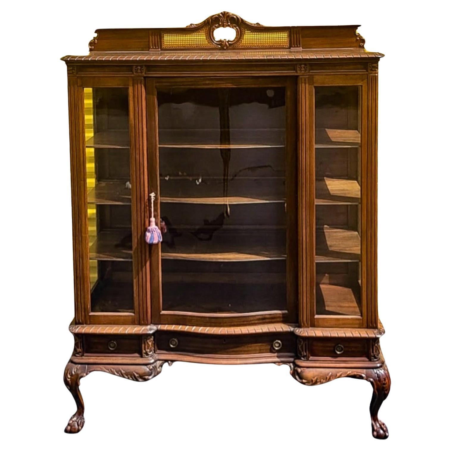 This is an early display cabinet with French styling. It has a heavily carved frame with ball and claw feet. I believe it to be oak. It does have the key. The wood shelves don’t appear to be adjustable. The clearance from top down is 11.5”, 9”, 9”,
