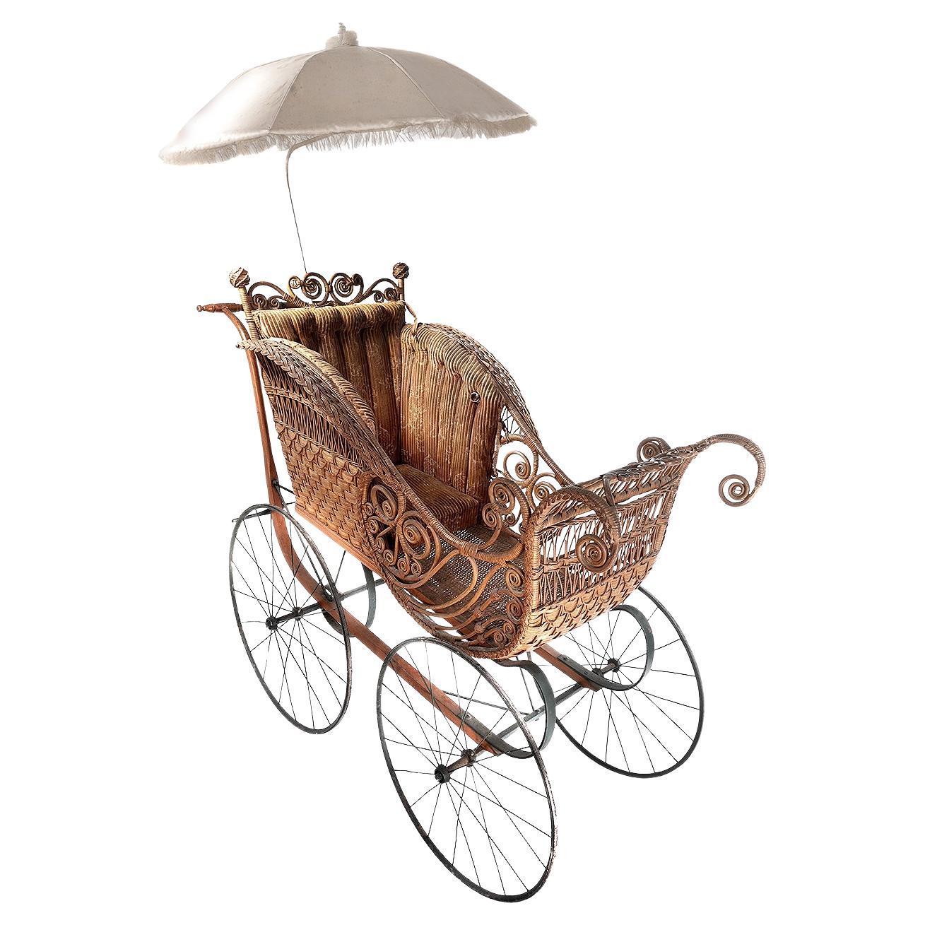 This is a great Victorian display piece that is all original including the fabric interior and parasol. The iron work carriage and spoke wheels are in nice condition. All the decorative wicker is there and looking fresh minus one small curl. The