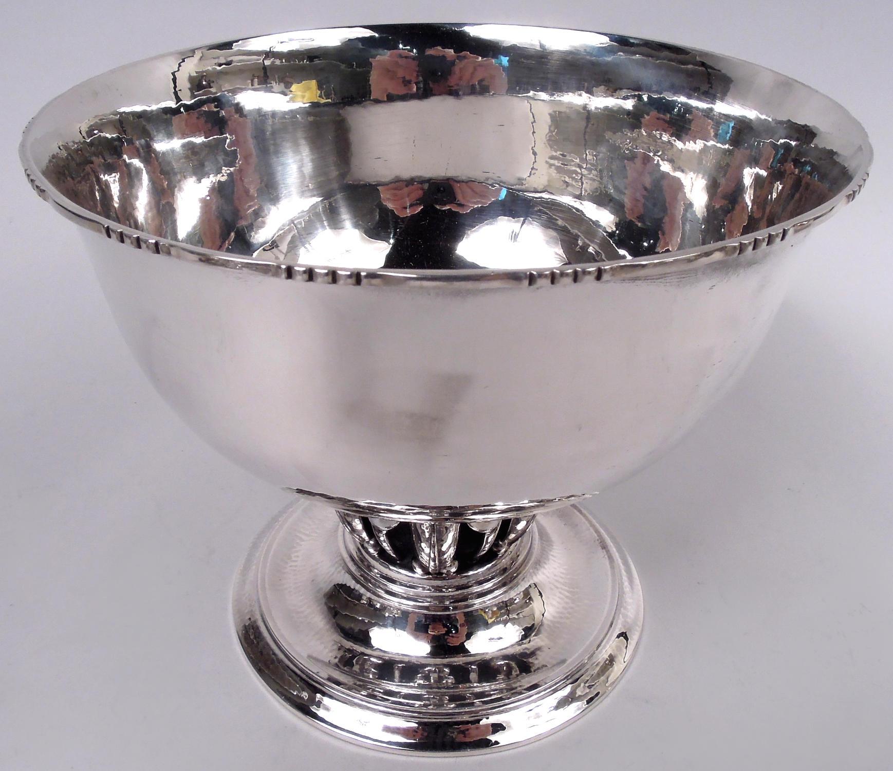 The classic sterling silver Louvre bowl. Made by Georg Jensen in Copenhagen. Round and curved; rim flat with alternating scrolls and scallops; raised and stepped foot. The open support with beaded leaves and tendrils reflects the stylized naturalism