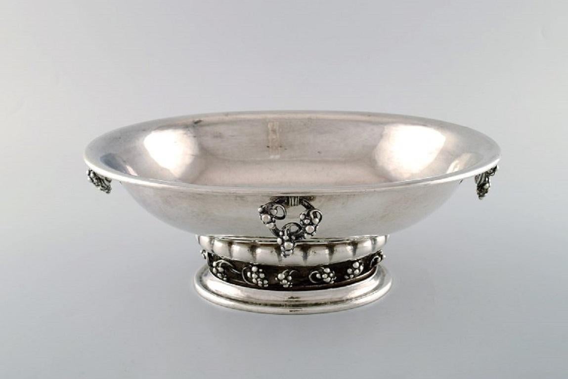 Early Georg Jensen large and impressive champagne cooler / centrepiece in hammered sterling silver, adorned with handles and ornamentation in the form of grapes.
In very good condition.
Model number: 296B.
Early stamps: 1915-1930. Stamped 296B