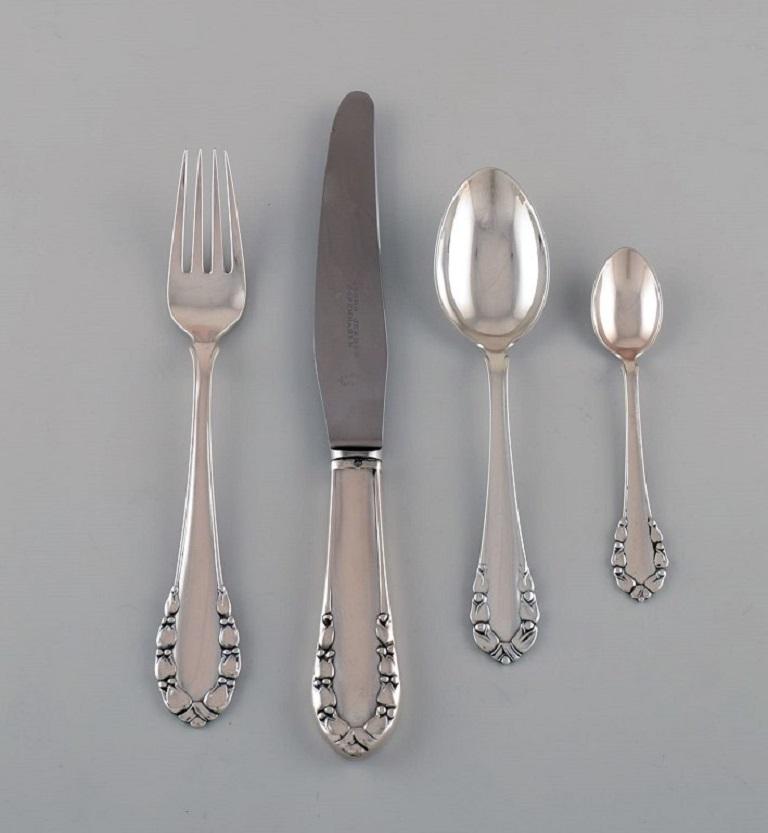 Early Georg Jensen Lily of the Valley dinner service in silver 830 for twelve people. All parts dated 1915-1930.
Consisting of twelve dinner knives, twelve dinner forks, twelve dessert spoons, twelve teaspoons, three serving spoons, two cold meat