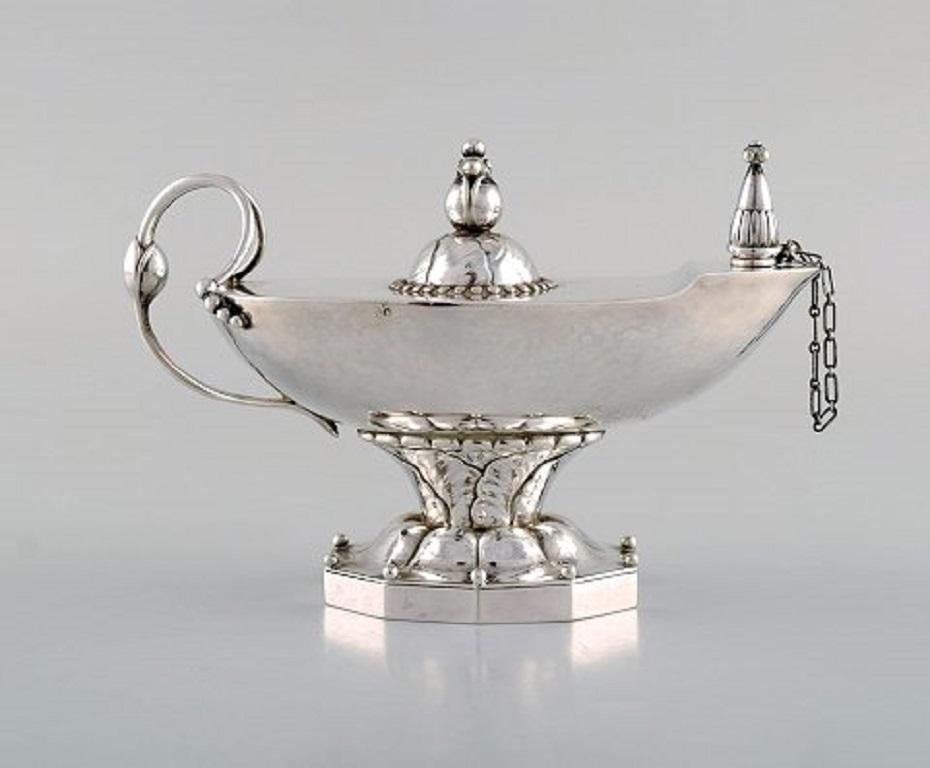 Early Georg Jensen oil lamp in sterling silver. Lid and stem with foliage. Edged base with pearls. Design 12.
Dated 1933-1944.
Measures: 13.5 x 8.5 cm.
In very good condition.
Stamped.