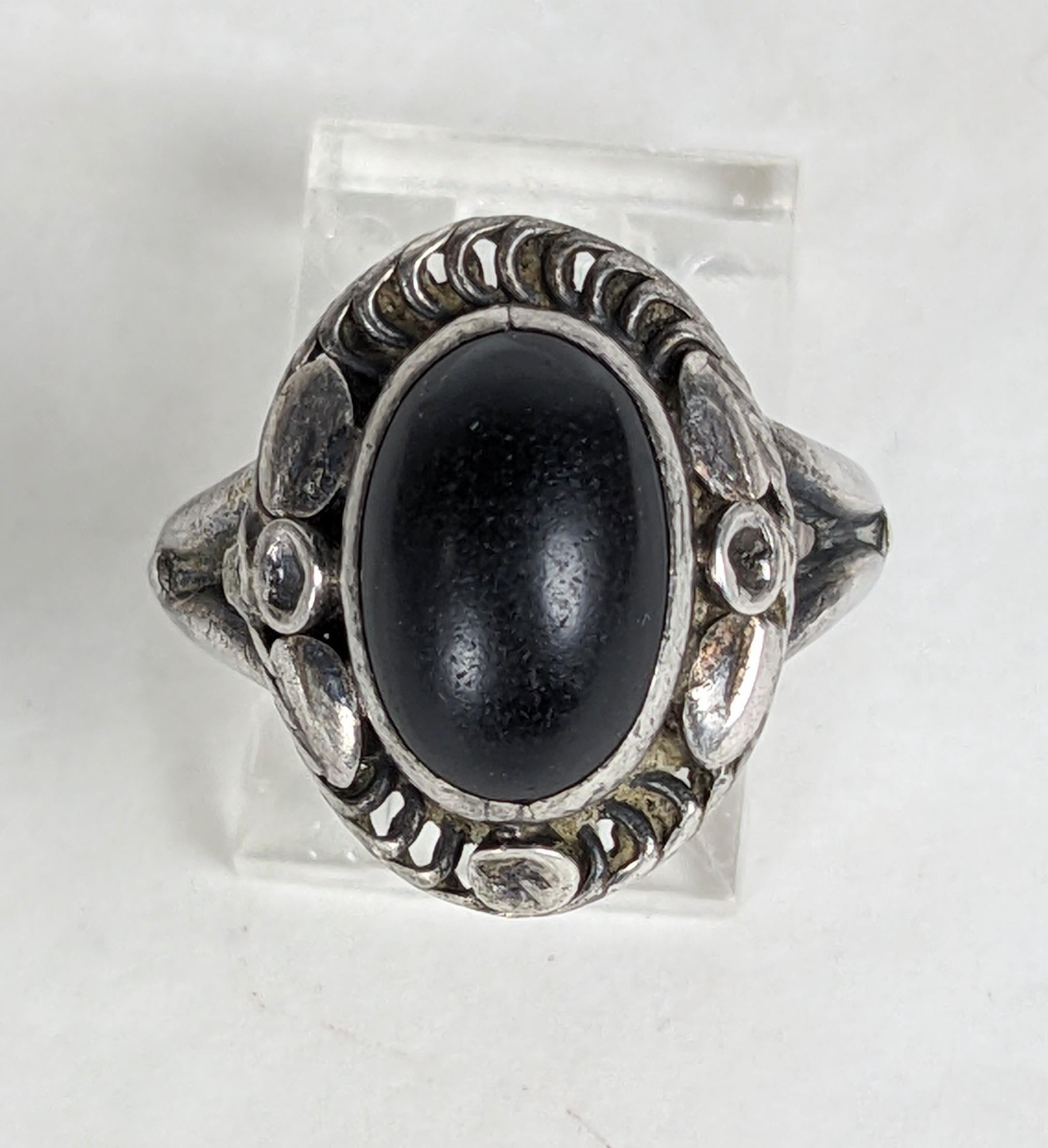 Lovely Early Georg Jensen Onyx Ring in foliate sterling setting from the Moonlight Blossom Series. Bezel set cabochon onyx with swirled wirework and leaf applications. Early 
