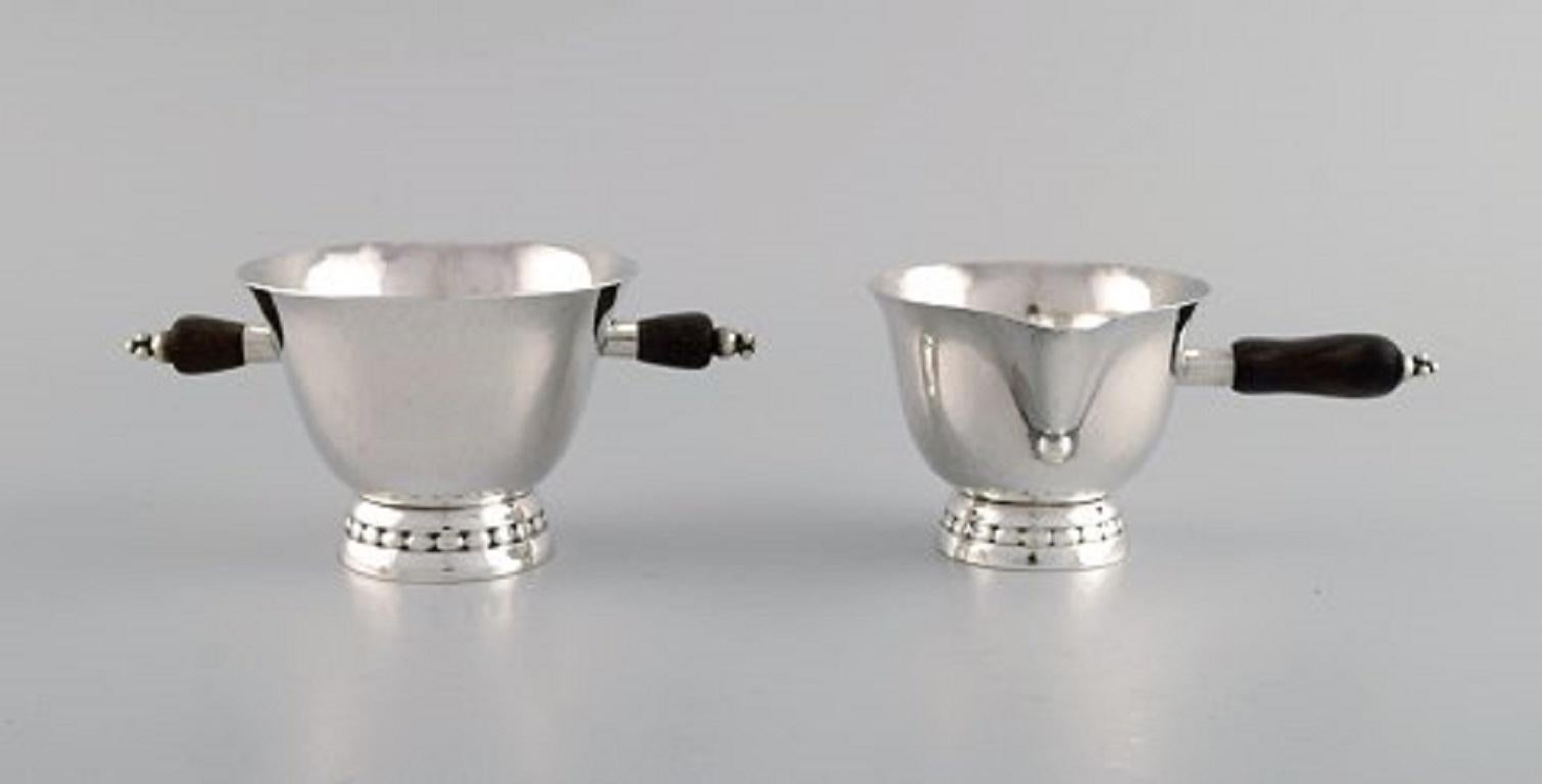 Frühes Zucker- oder Cremeset von Georg Jensen aus Sterlingsilber mit Griffen aus Ebenholz. Datiert 1915-1930.
Die Zuckerdose misst: 13.5 x 6,5 cm (einschließlich Griffe)
In ausgezeichnetem Zustand.
Gestempelt.