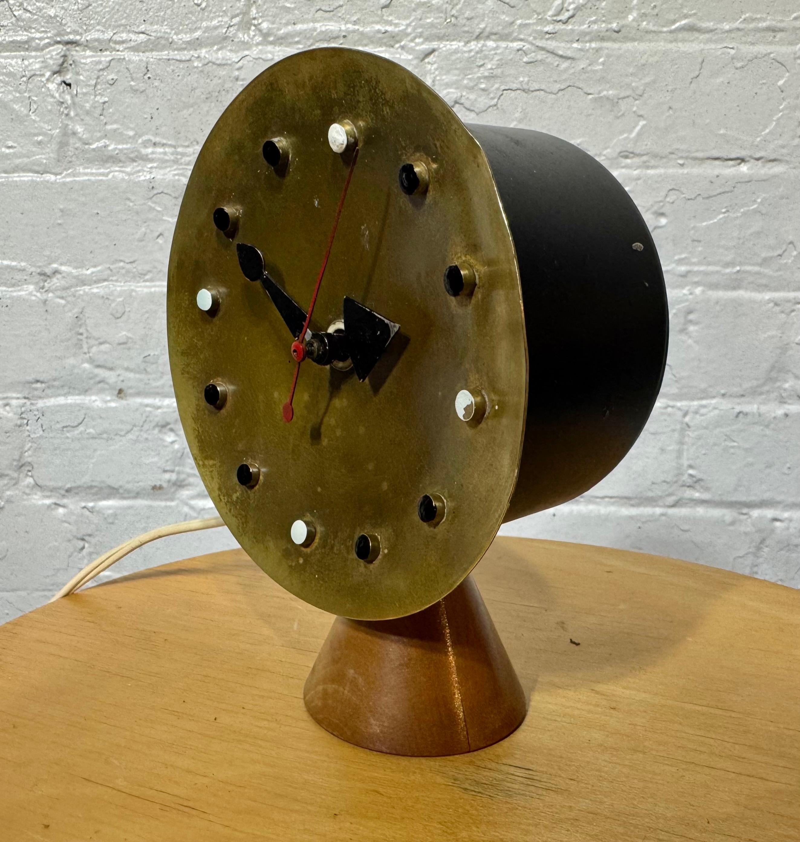 A rare original George Nelson desk or table clock. Very unique bronze metal face and motor housing on beautiful wood cone base  Remnants of original Howard Miller Clock Company Zeeland Michigan label. The clock is working with wonderful original