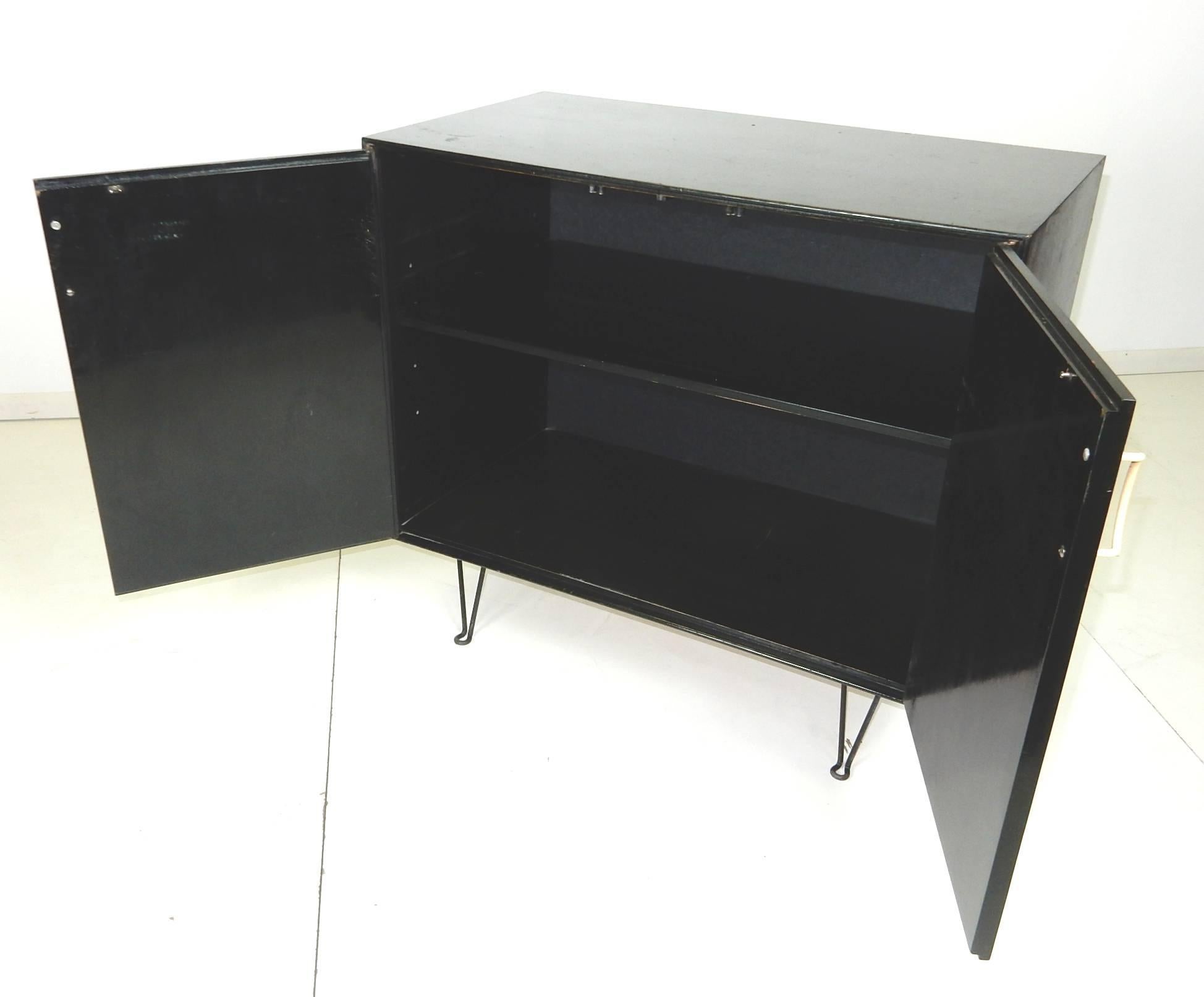 Early 1950s two-door cabinet from the thin-line line designed by George Nelson
for Herman Miller.
Single adjustable inner shelf. Wire pulls and legs.
Completely original with no damage or repairs.