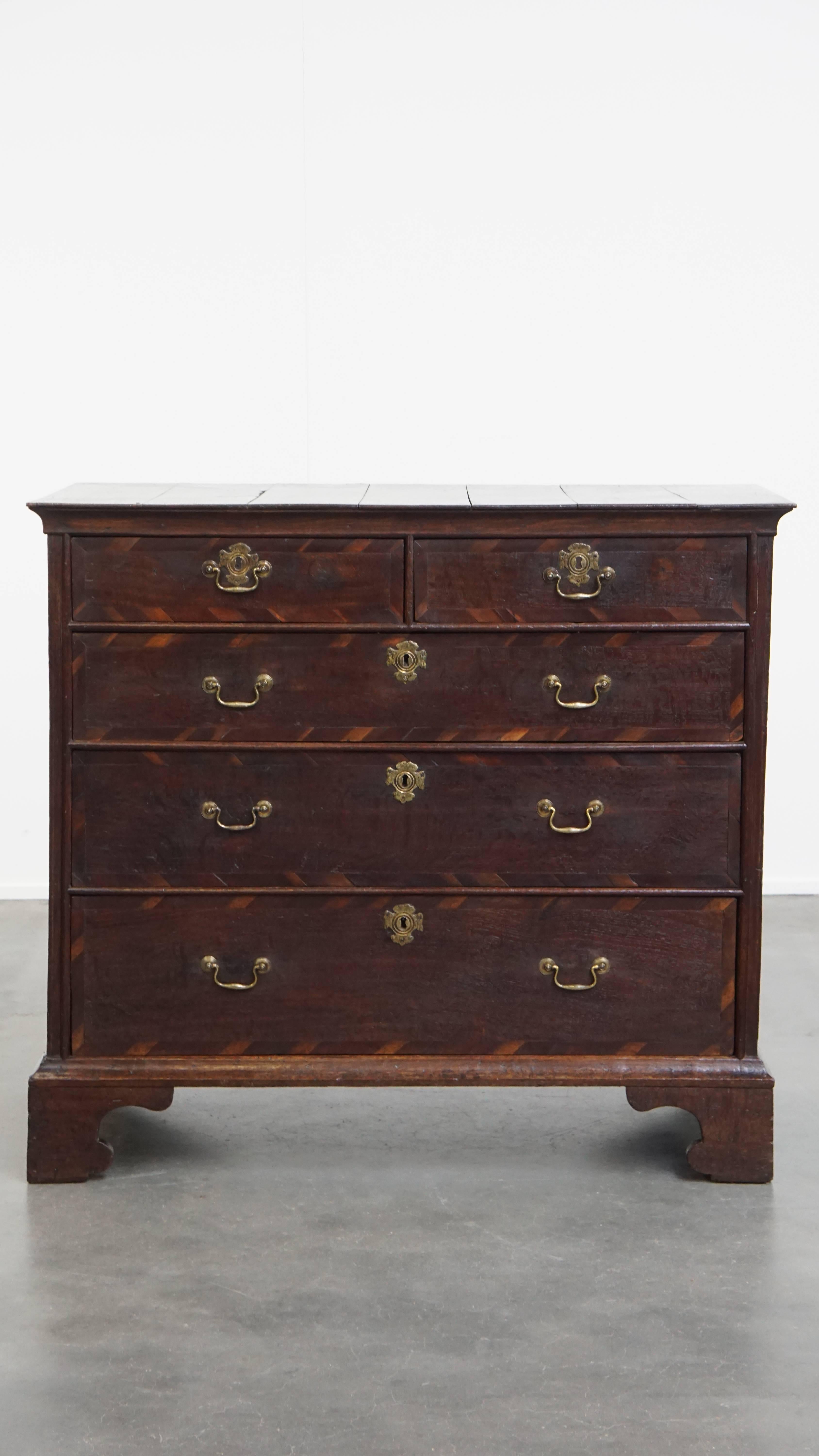 Offered: this English antique and elegant early Georgian oak chest of drawers with unique inlay made from various wood types.
This exceptional antique oak chest of drawers is without a doubt a true eye-catcher. What makes this piece particularly