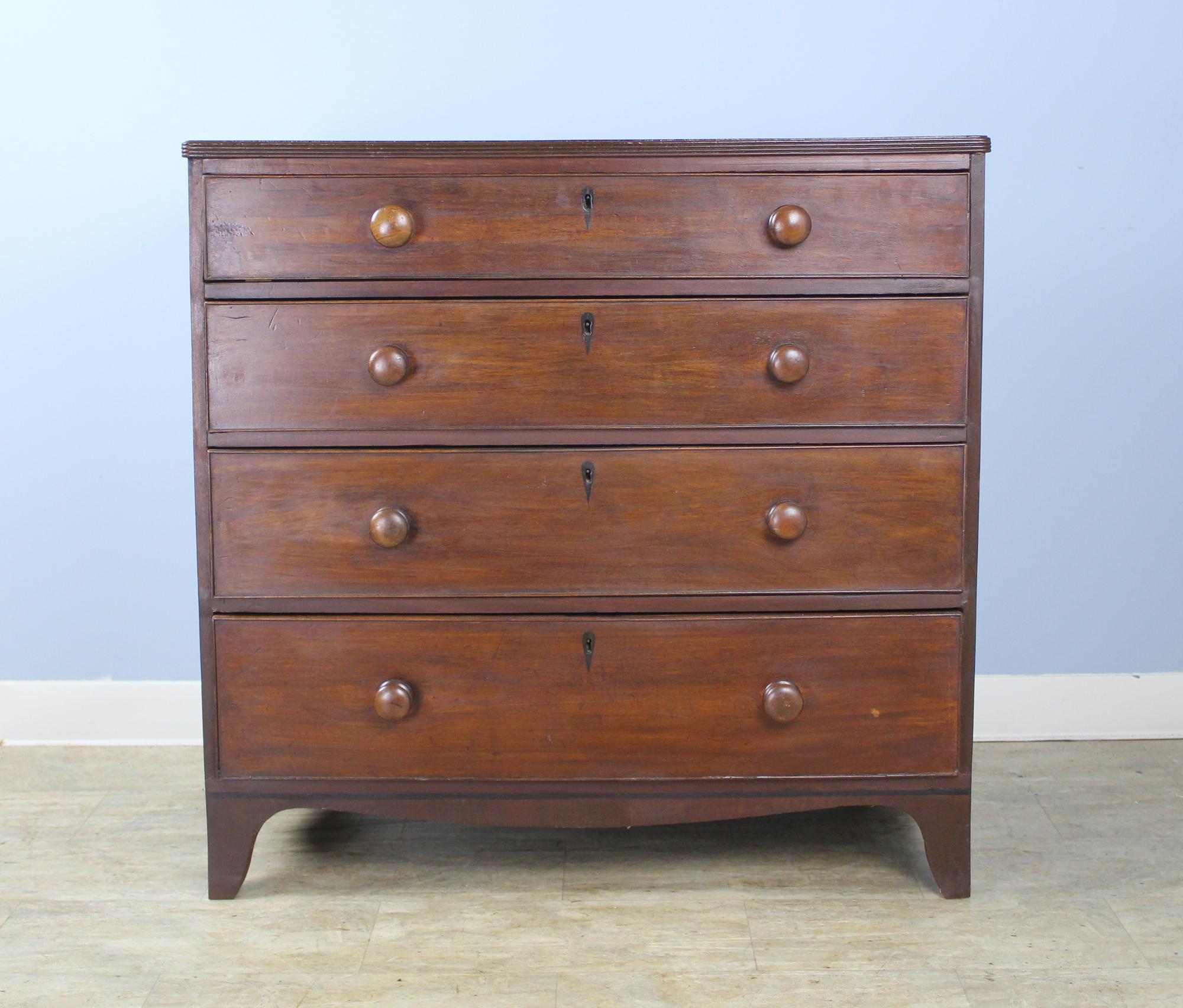 A handsome early English chest with deep drawers inlaid with ebony detail. Classic round knobs. There is a small reeding around the edge of the top, typical of the period. Flared feet add to the look. Note: The top has been completely refinished.