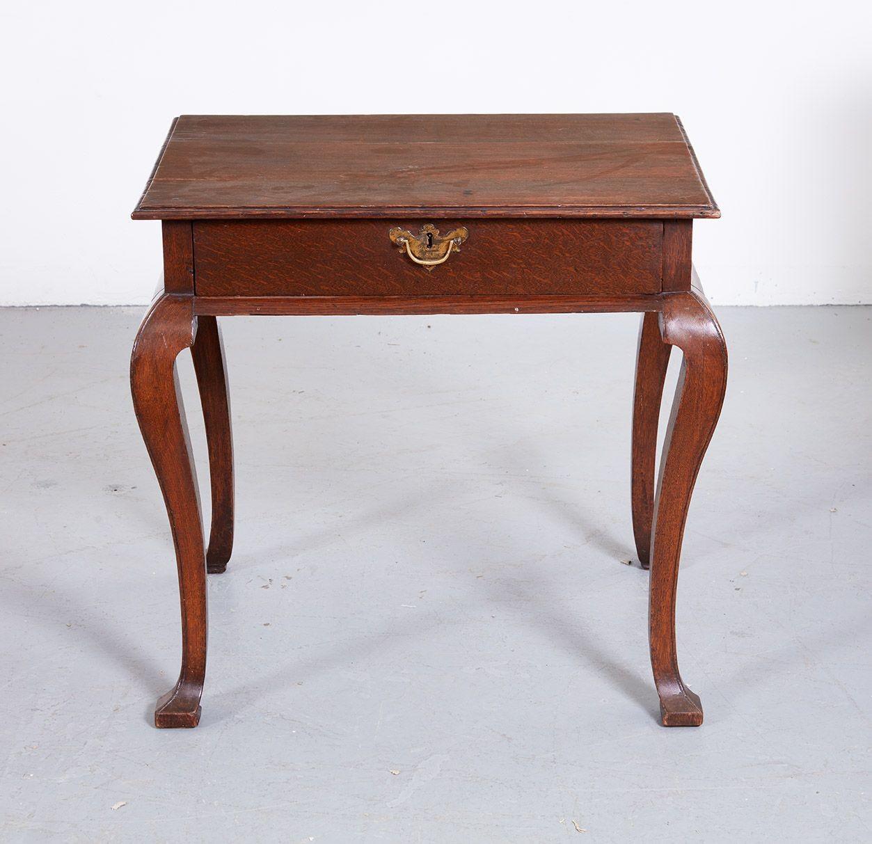 Early 18th century English oak table, the ogee molded top over single drawer retaining original gilt lacquer brass hardware, with quarter round molded apron, standing on square cut cabriole legs with beaded edge, the whole with good color and timber.