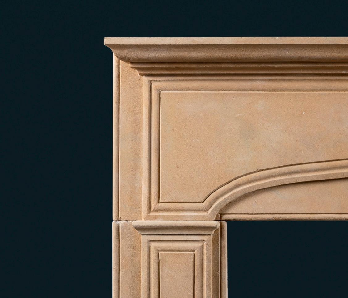 A large and dignified early eighteenth-century Queen Anne or George I stone frame fireplace surround, the shallow shelf above shallow arched frieze and jambs with carved fielded panels, centred by tapered and fluted keystone, the aperture framed