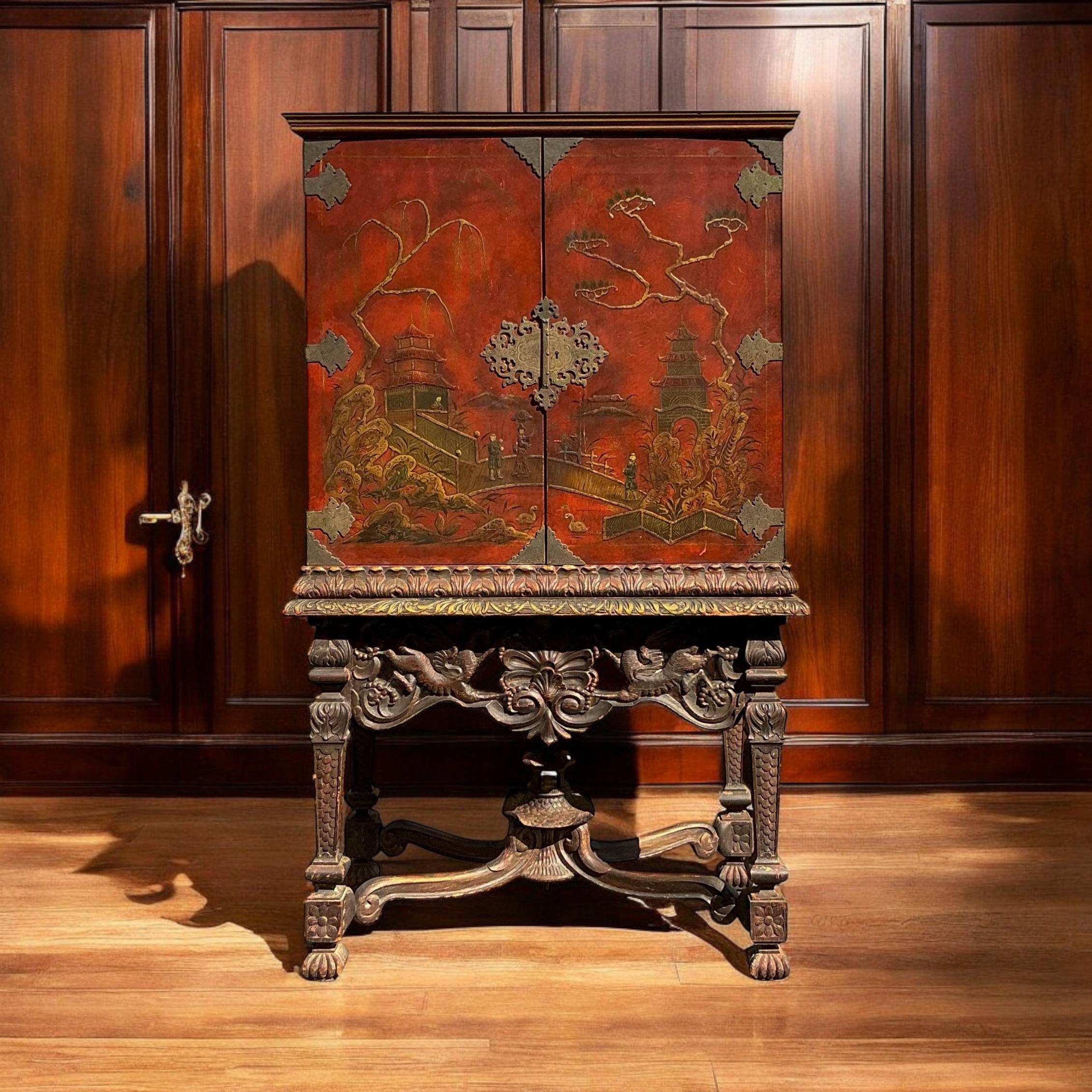 This is an early 20th century Georgian style chinoiserie secretary cabinet on a heavily carved shell and pagoda form base. It is two pieces. The cabinet has a fitted interior giving it ample storage. The exterior is a hand painted chinoiserie scene