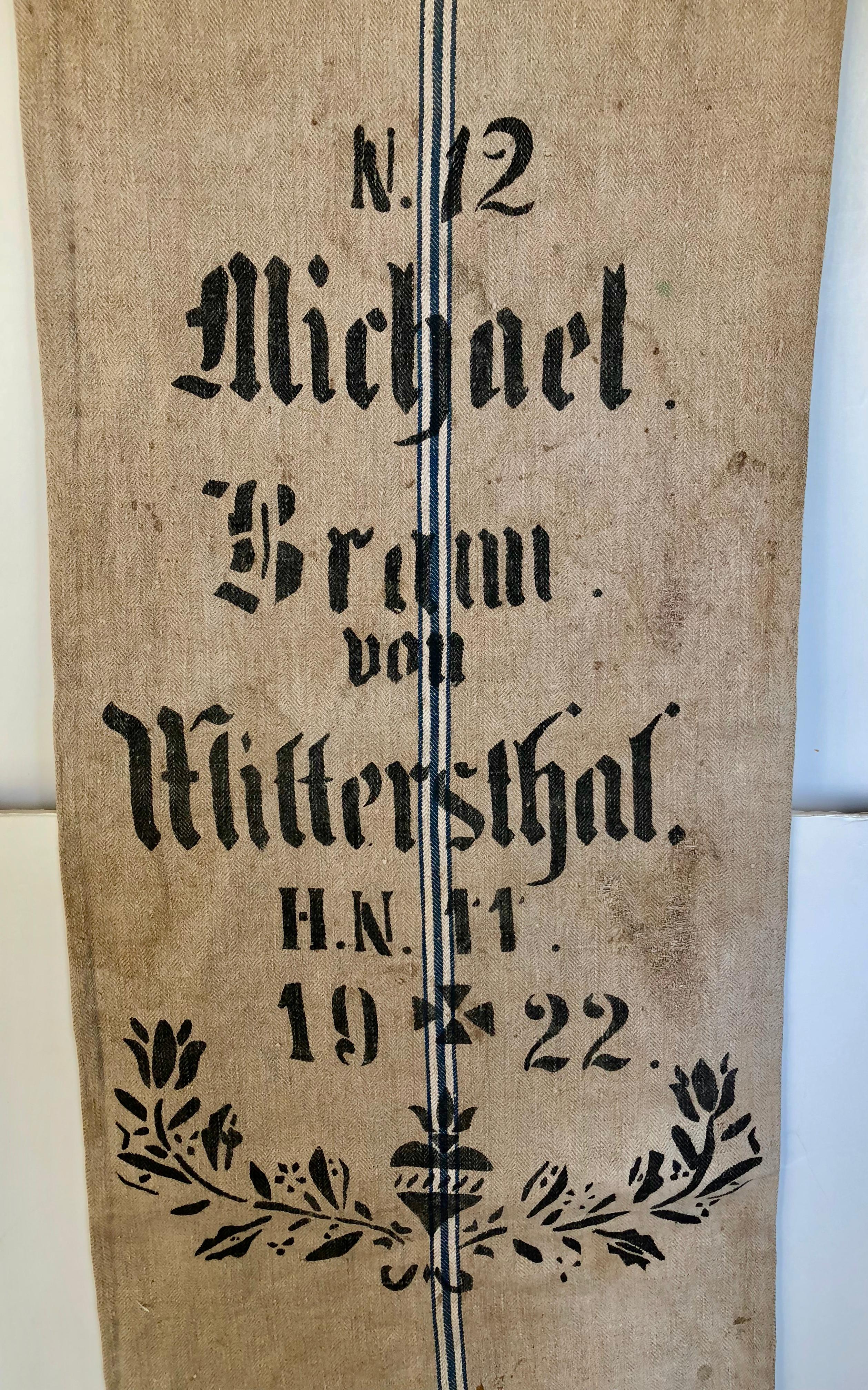 Early German handwoven grain sack with original calligraphy and graphics. It was made from linen and hemp by the farmer's wife and used to store grains in the barn. The farmer's name, town inventory # were stamped with black tar, it is very rare to