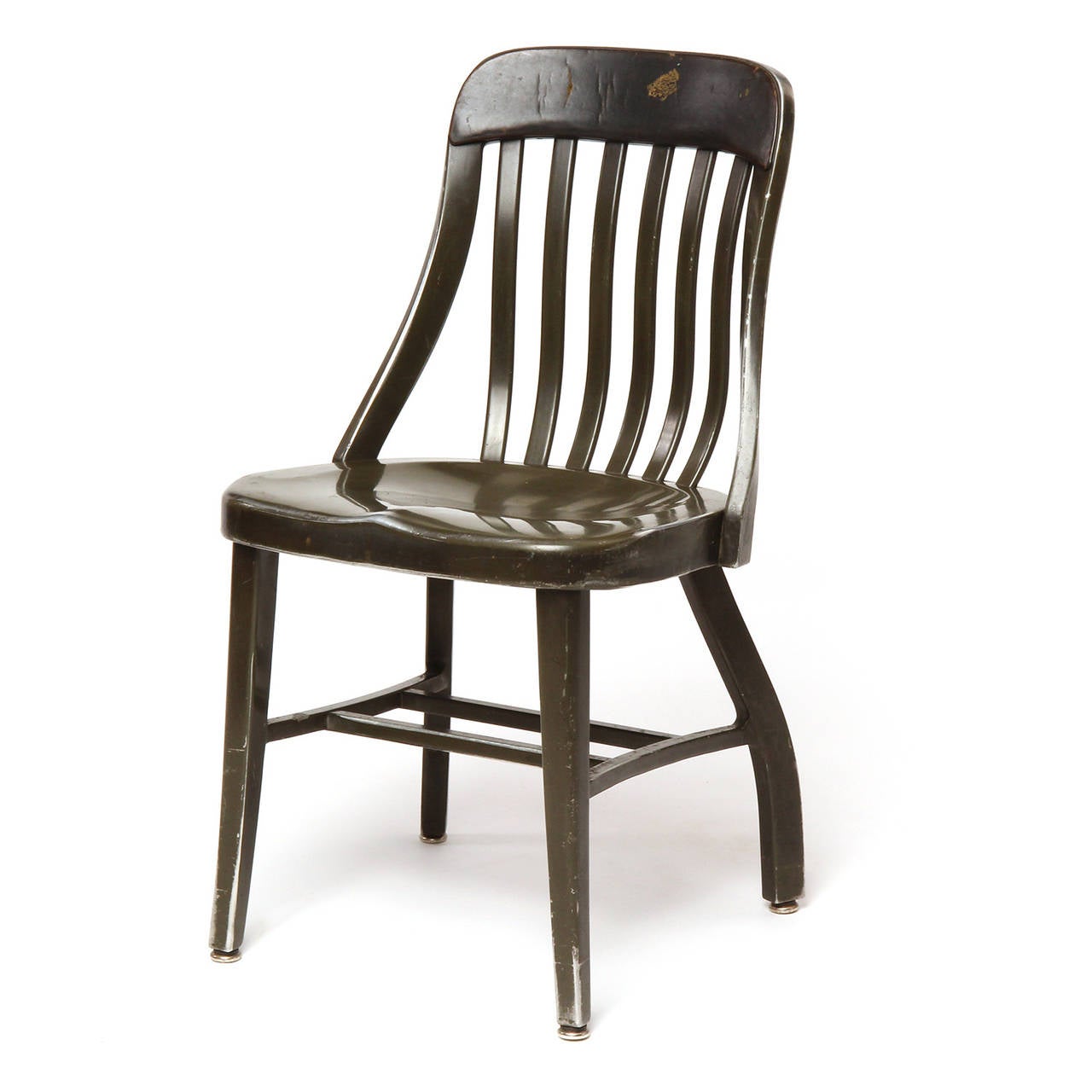 An early GoodForm armchairin original finish. Made of cast and formed aluminum with a slatted undulating back and thin leather pad on the top of the backrest.