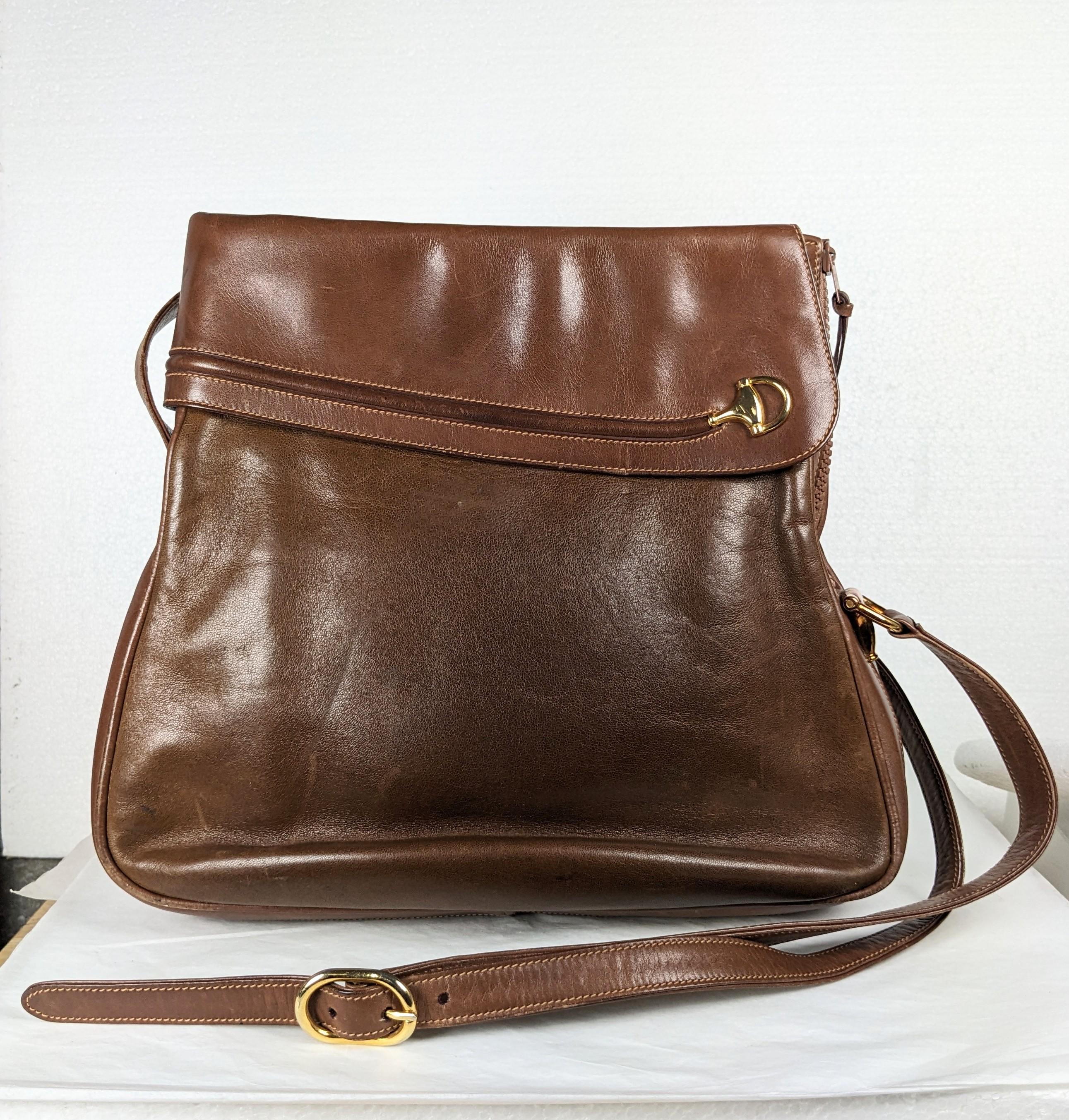 Early and unusual Gucci Bridle Motif Trimmed Leather Bucket Bag from the 1970's Italy. Open top design with side zipper on end of bag for entry. Classic horse inspired design in brown leather with even patination throughout. 1970's Italy. 10
