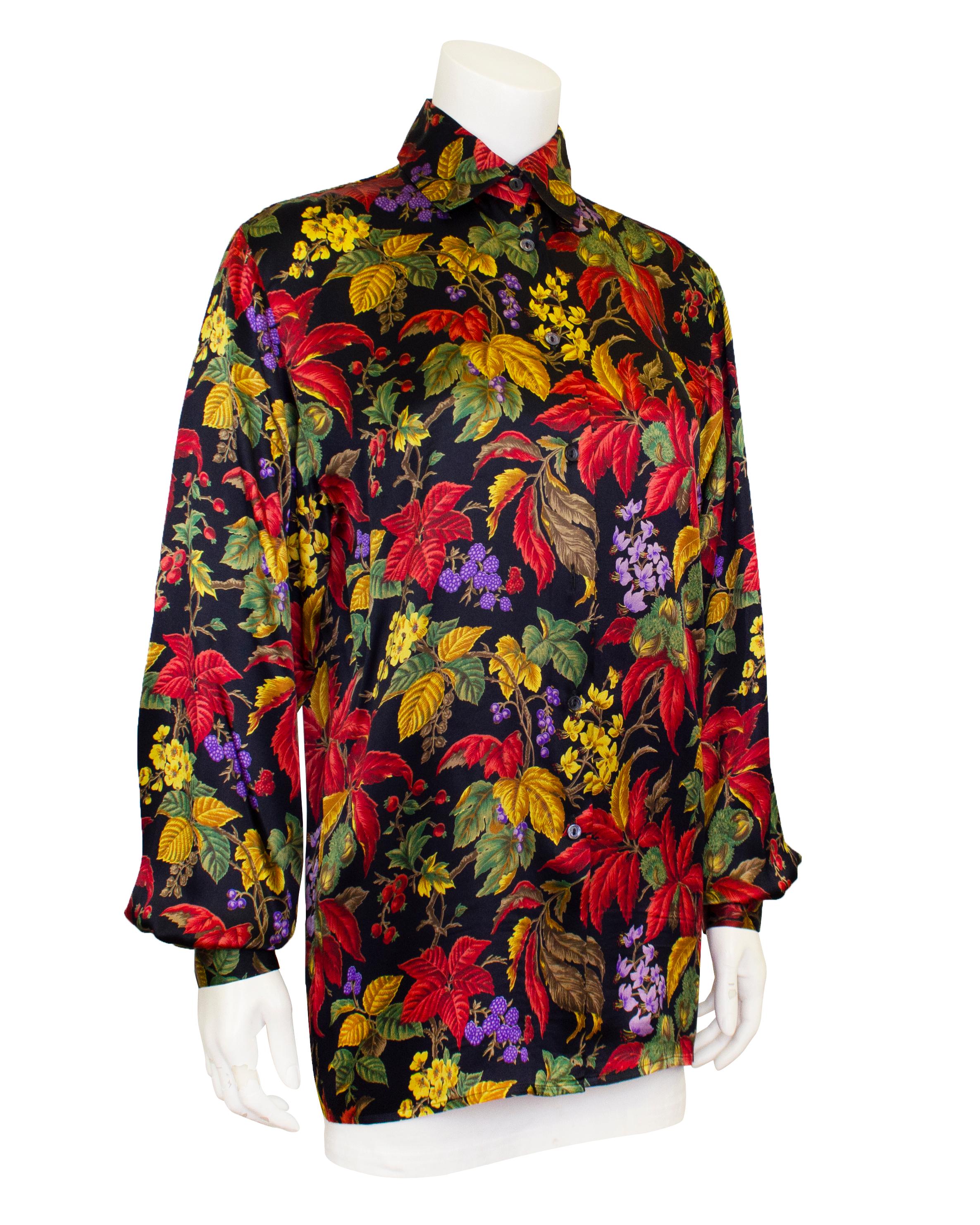 Stunning Gucci printed silk blouse from the 1970s. The all over raspberry bush botanical print features stunning rich shades of yellow, red, green, purple and brown on a black background. The blouse is almost tunic length with oversized bishop