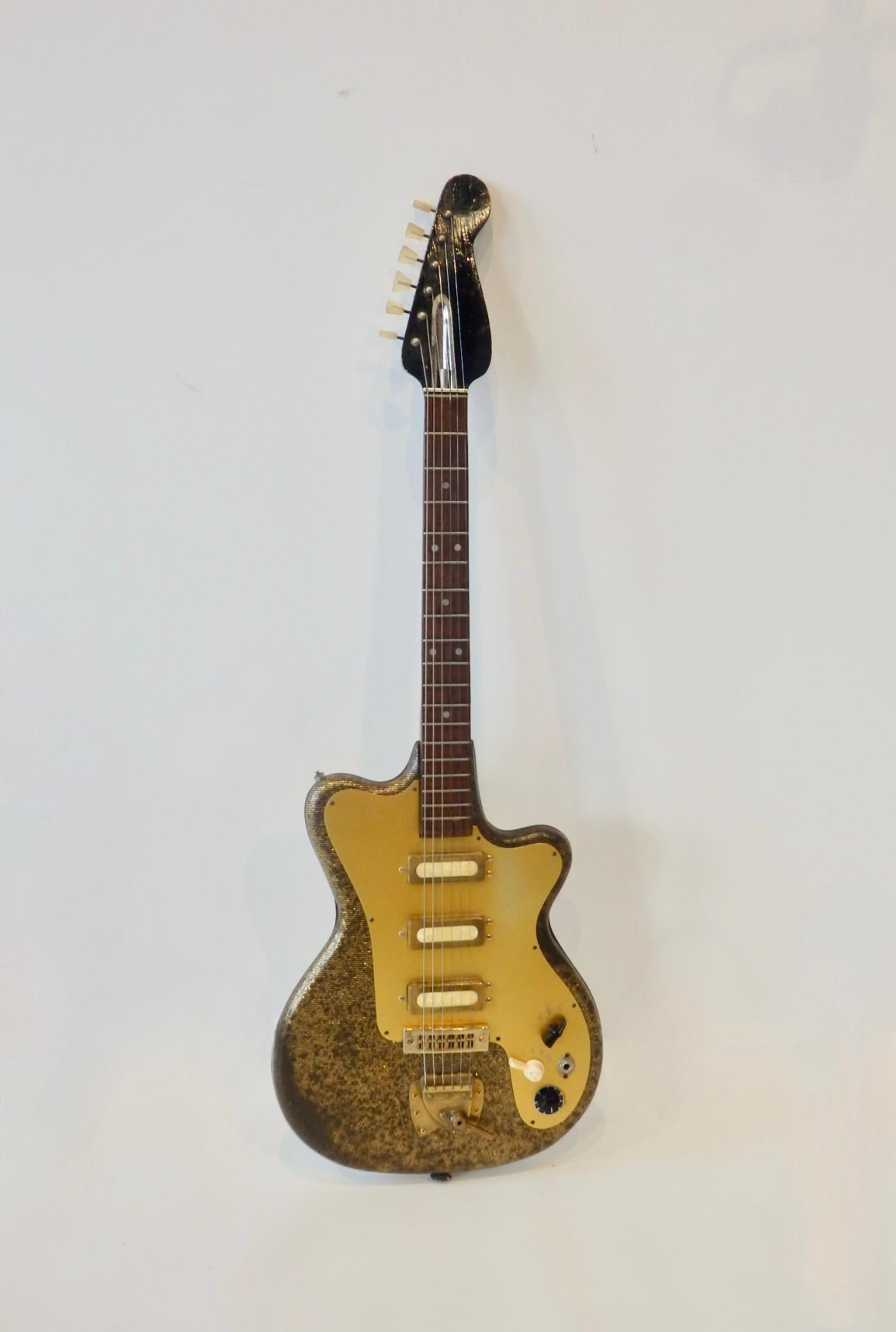 Early and scarce German solid body electric guitar. Crafted by Fasan guitars . Body is wrapped in a gold metal flake  with black line detail covering. An interesting early guitar that was well loved and has more to give. Fretboard appears to be