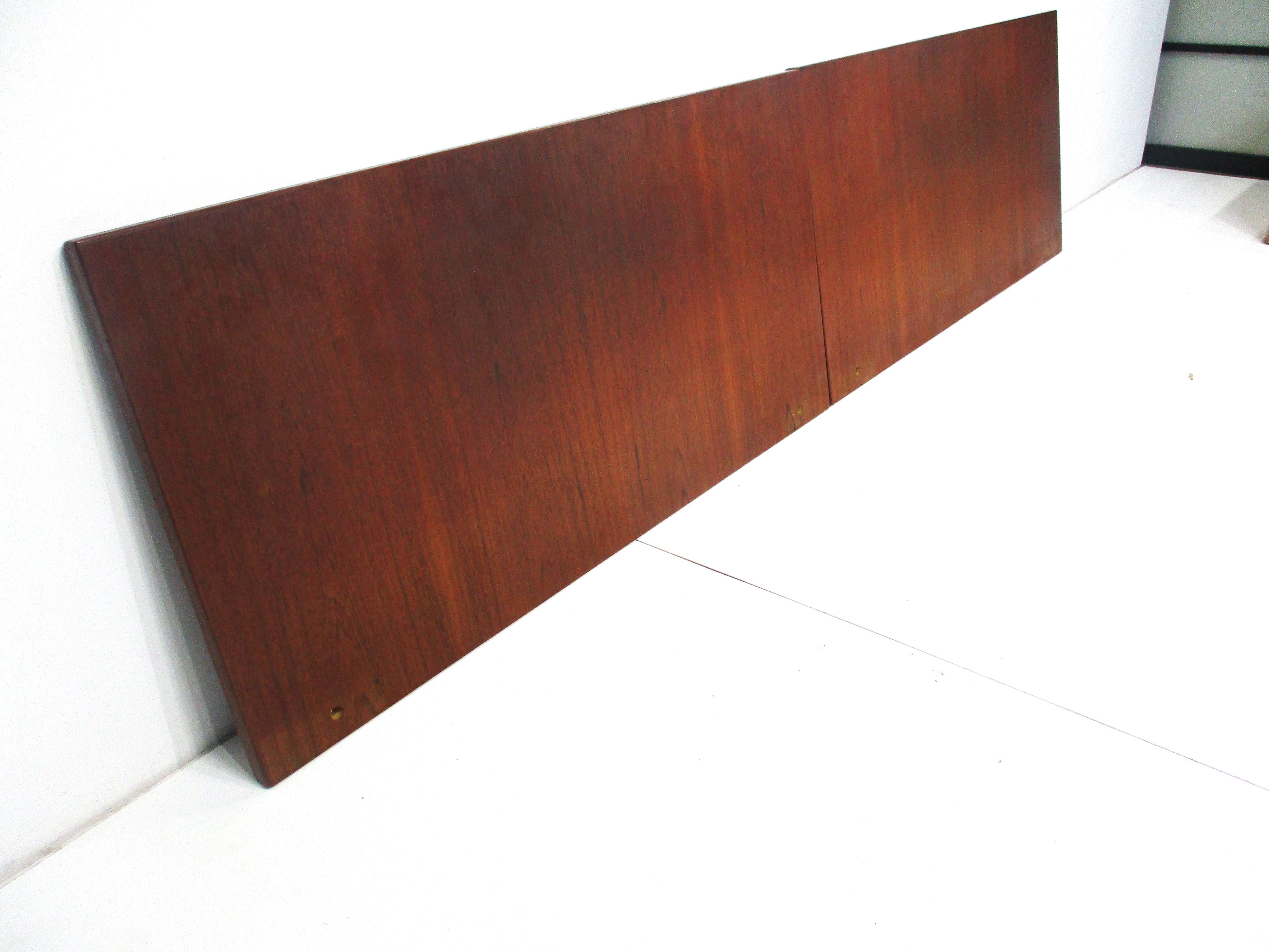 A teak two piece king sized Danish headboard , mounts to the back of the bed frames , platform or wall with four cast steel L brackets which are included . Ordered in 1962 by the former owner directly at the Povl Dinesen showroom in Copenhagen which