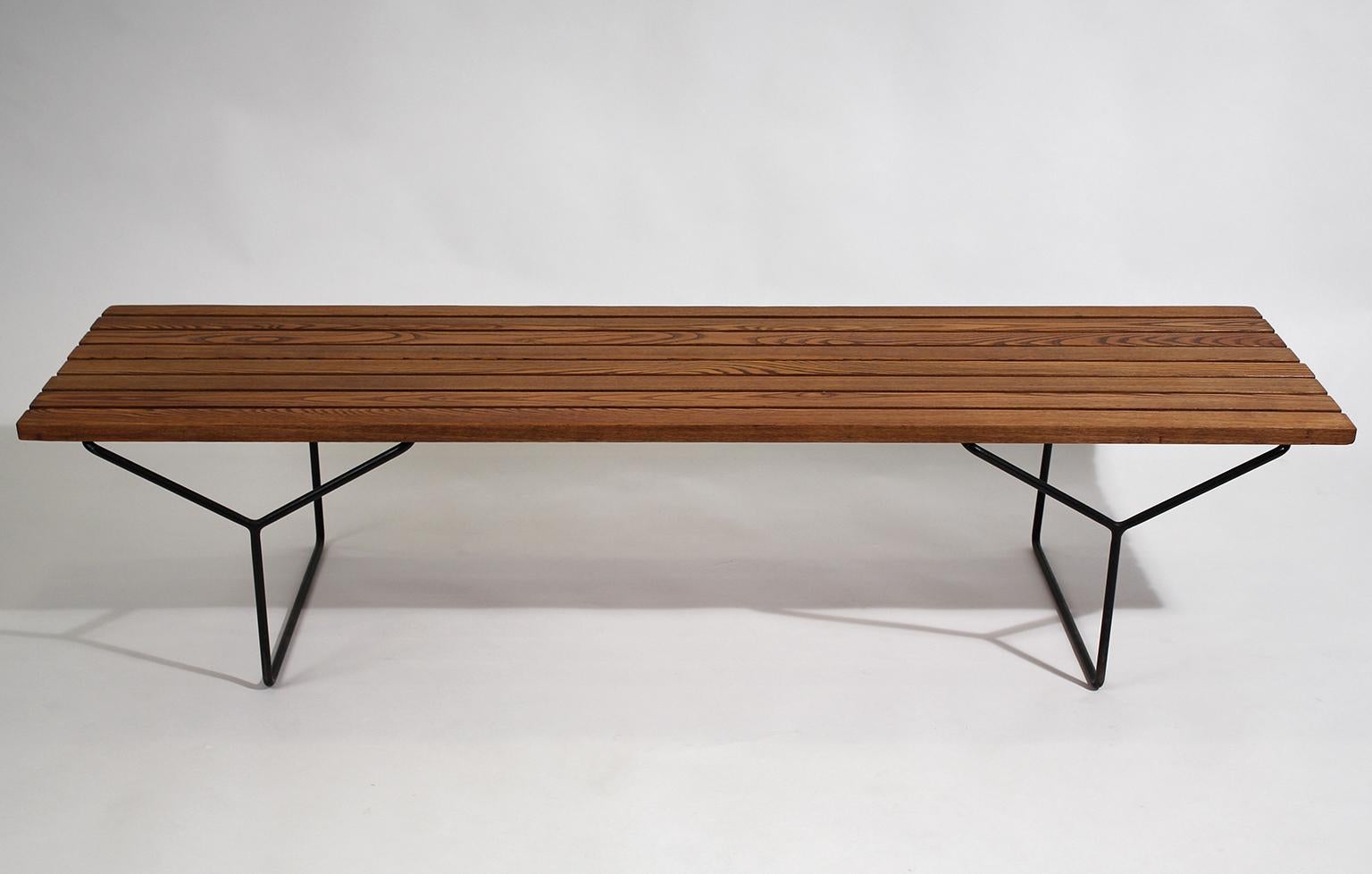Early Harry Bertoia designed wood slat bench for Knoll International, circa 1960. Awesome form and design. Has wrought iron legs and the wood has wonderful color. In excellent original vintage condition. Tough to find early bench.