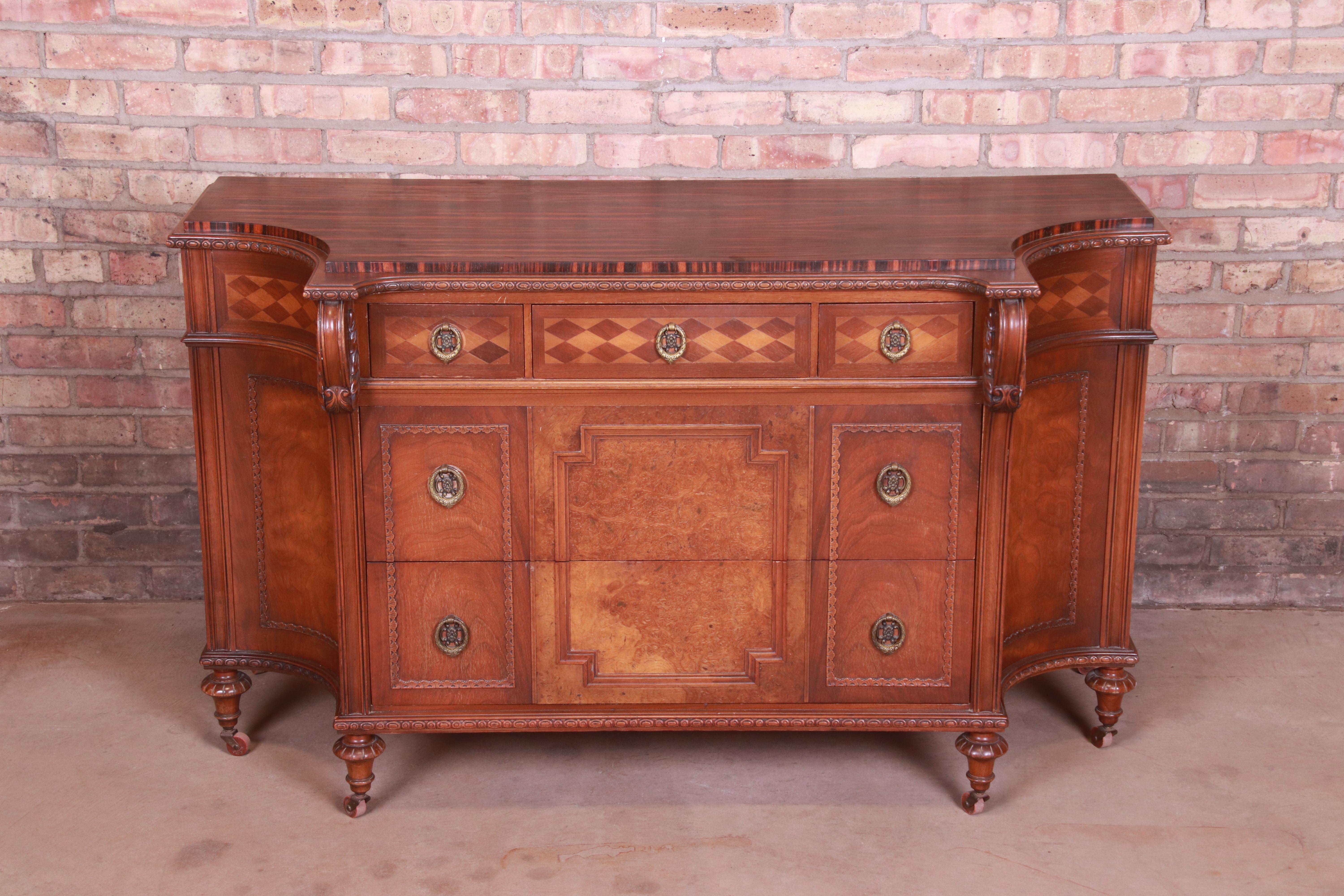 A rare and exceptional antique chest of drawers, commode, or buffet server

By Herman Miller

USA, circa 1920s

Carved walnut, with burled walnut drawer fronts, exotic calamander wood top, and original brass hardware.

Measures: 54.13