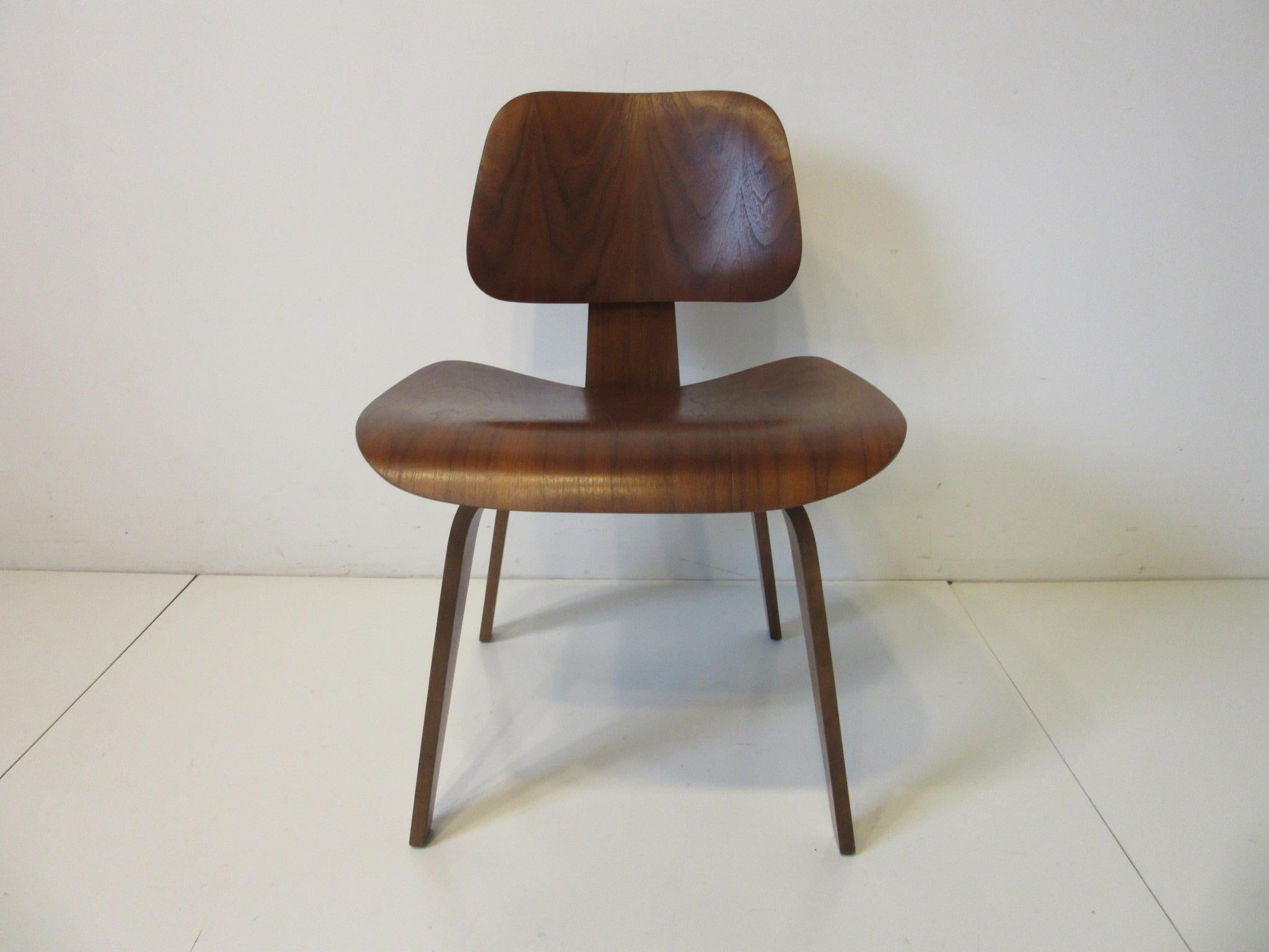 A dark walnut sculptural molded plywood side chair with early five screw configuration to the base constructed in the 1950's this iconic Mid Century design still feels fresh after all these years . Manufactured by the Herman Miller Furniture company