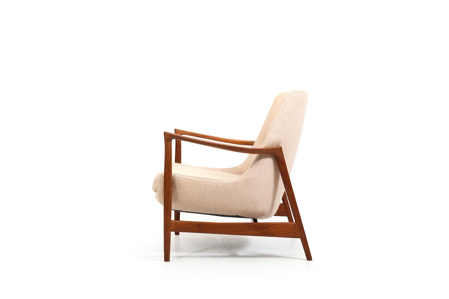 Early Ib Kofod Larsen easychair, model 4346 in teak and creme fabric. Very early production with the old Fritz Hansen mark 1950s (see last pic) In absolutely original condition , with nice patina.