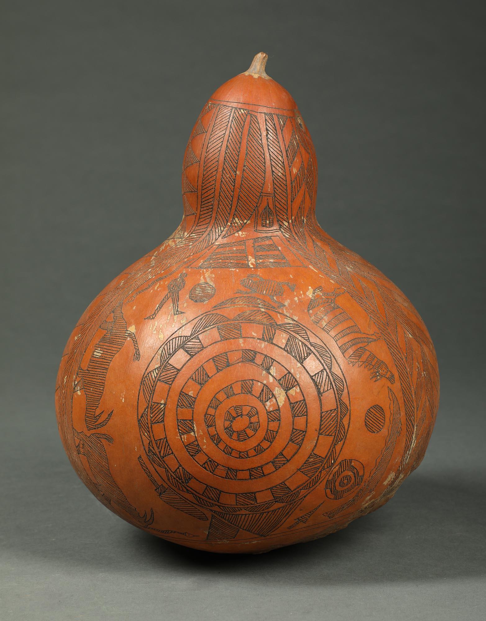 Sonajero de calabaza de una sola pieza tallada incisa, procedente del África congoleña.

Se muestran grandes historias (desconocidas) que incluyen un hombre, una serpiente, dos rinocerontes, una cebra (?), un cocodrilo y, en el otro lado, una larga