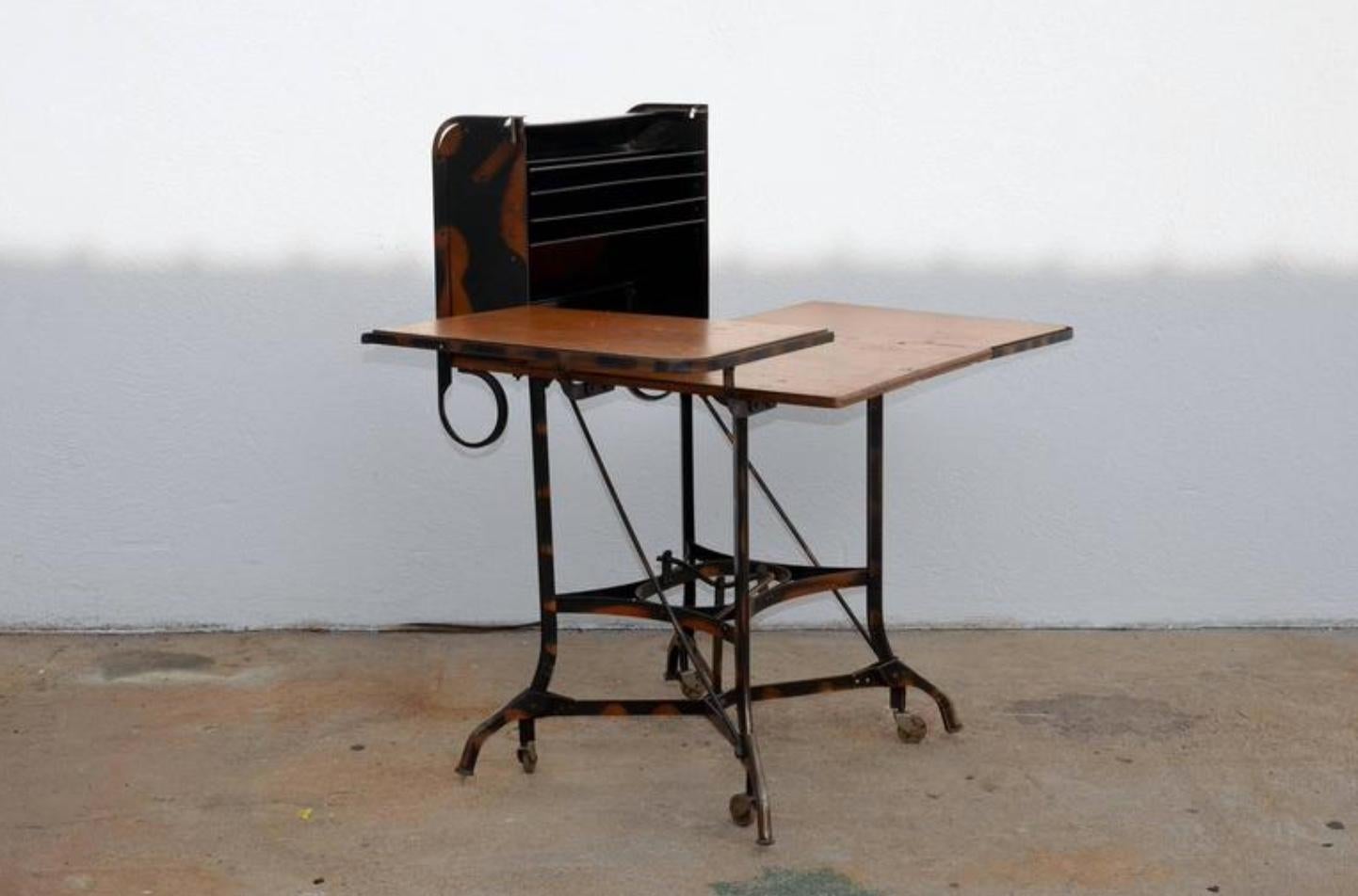 Early Industrial rolling desk by Toledo. Great for a laptop desk. A lever picks up the desk on wheels for easy moving and secures it back in place.
