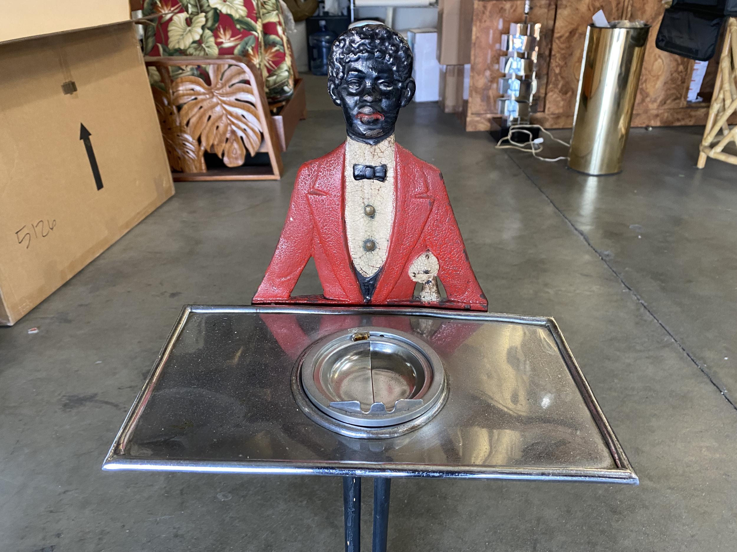Early iron Art Deco blackart butler ashtray server stand featuring a cast iron African American butler holding a chromed steel serving table with built in ashtray in the center. 

The original paint is excellent condition. 

Circa 1920.

  