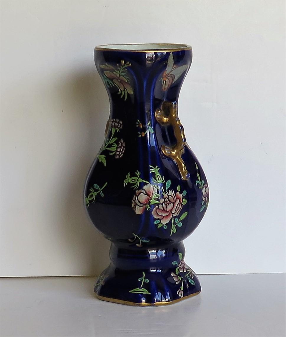 This is a finely hand painted ironstone vase, probably made by Zachariah Boyle of Hanley and Stoke, England, circa 1825.

Pieces by this manufacturer are fairly rare.

The vase has an octagonal shape with simulated salamander handles at the