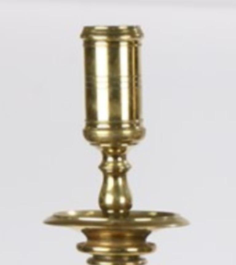 A pair of tall early Italian candlesticks in age-mellowed brass, with restrained baroque turning.