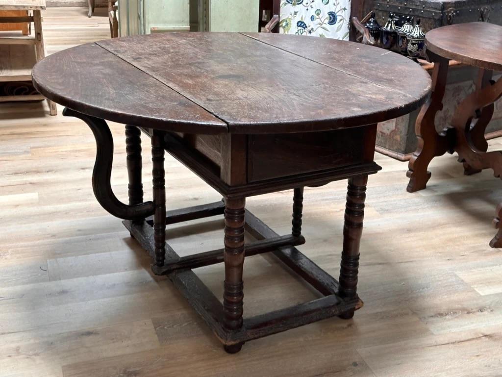 Early Italian Walnut drop leaf table.  The drop leaves opening to form an found table over a deep base resting on four turned legs attached by stretchers.

Dimensions:
Height	 32.25