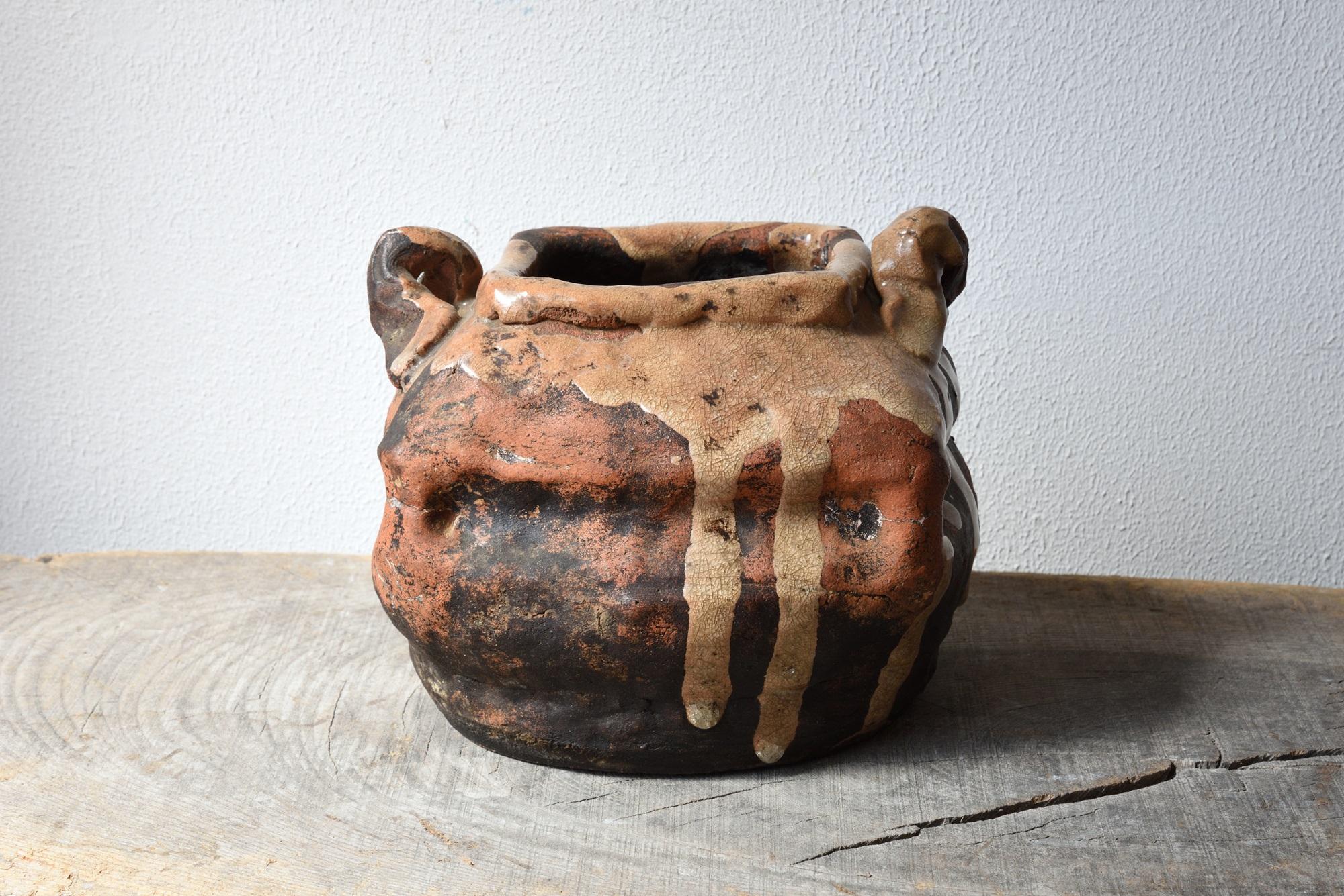 Unique and rare find of an old Japanese double-eared pottery tea utensil ware for the use of flowering or incense made of the well-burnt blackish clay containing rich in iron in the traditional but more like organic forming by refined tebineri