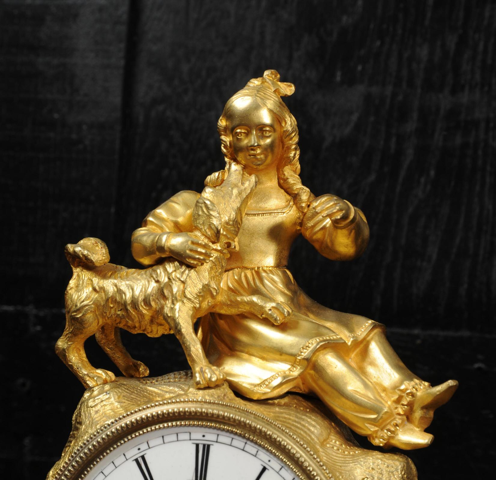 An early and stunning original antique French clock by Japy Frères, circa 1850. It features a charming figure of a girl with her favorite dog atop a naturally modelled rocky outcrop that house the clock. It is beautifully modelled in ormolu (mercury