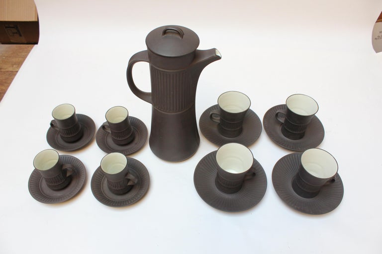 Denmark 'Flamestone' coffee or tea pot, four demitasses, four mugs, and eight saucers (four small / four larger) by Jens H. Quistgaard for Dansk Designs, circa 1958-1964.
Features the Flamestone signature slate, almost brown glazed-earthenware with