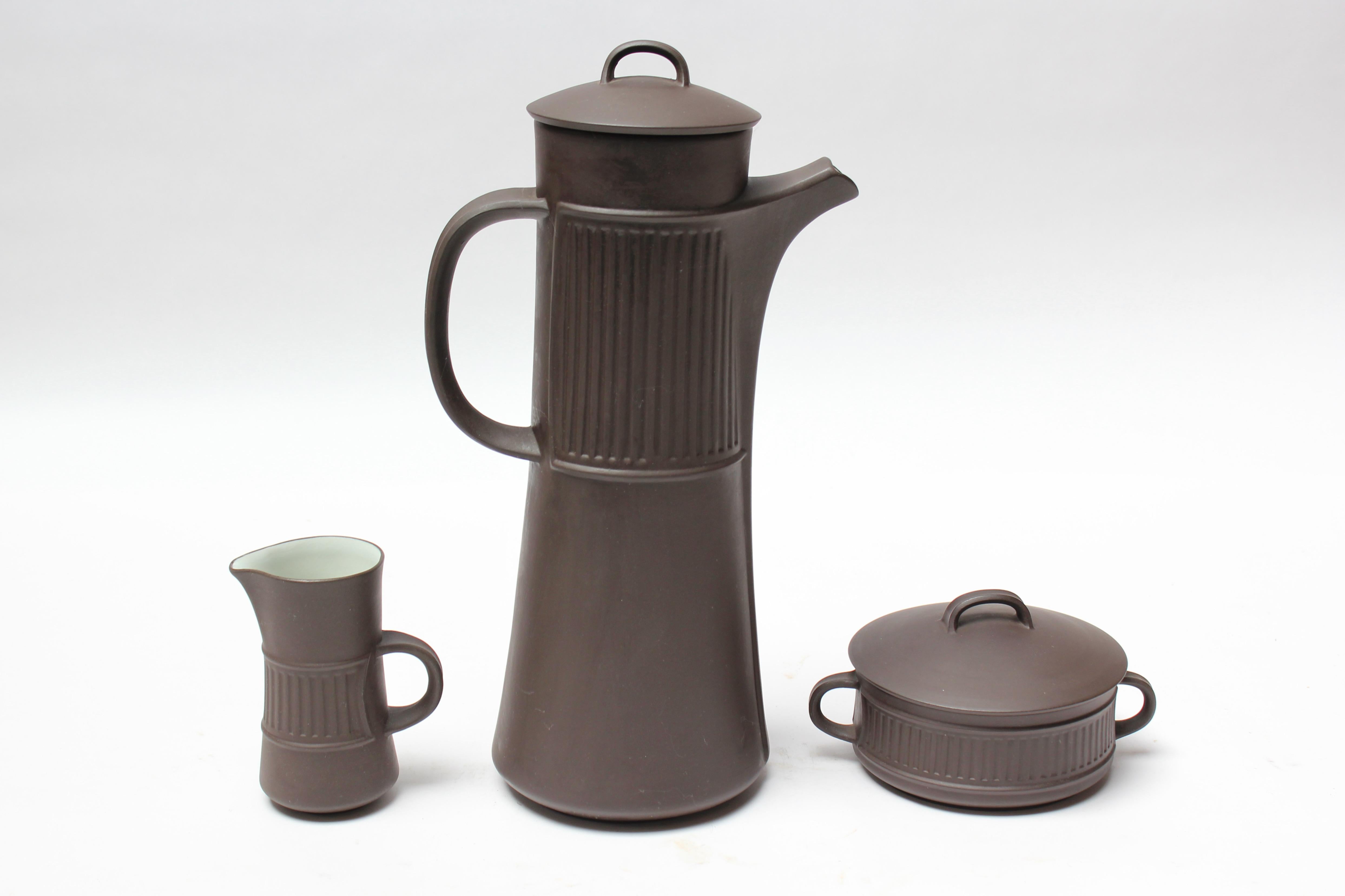 Denmark 'Flamestone' coffee or tea pot, creamer, and sugar by Jens H. Quistgaard for Dansk designs, circa 1958-1964.
Features the Flamestone signature slate, almost brown glazed-earthenware with striated pattern and white with a tinge of green