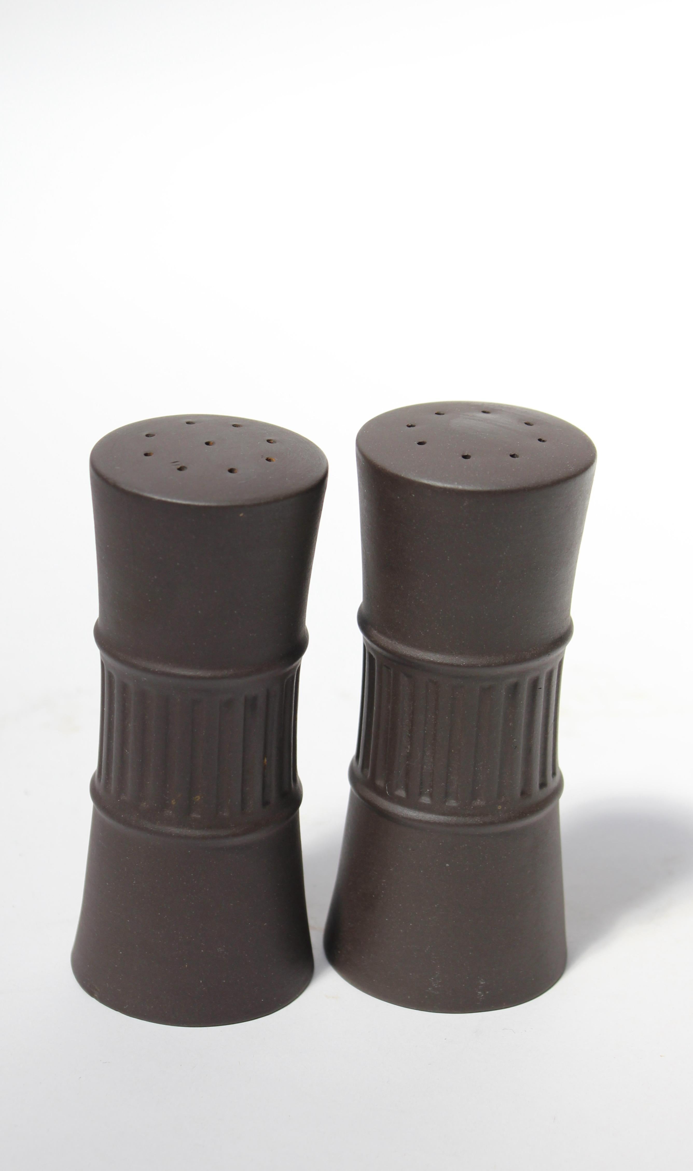 Danish 'Flamestone' earthenware salt and pepper shakers by Jens H. Quistgaard for Dansk designs, circa 1958-1964. Features the Flamestone signature slate glaze with striated pattern (glaze can appear brown, lighting depending). 
Elegant, design with