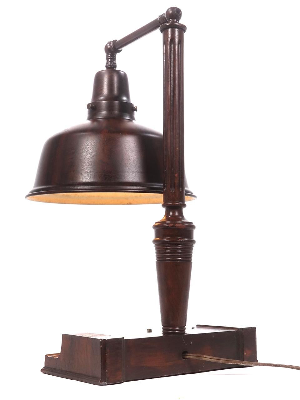These are heavy industrial quality brass table lamps. These lamps date to the 1930s. They have a wood grained metal finish and an oversized shade. Perfect for showing off watches and diamonds. The finish and paint are untouched showing the aged