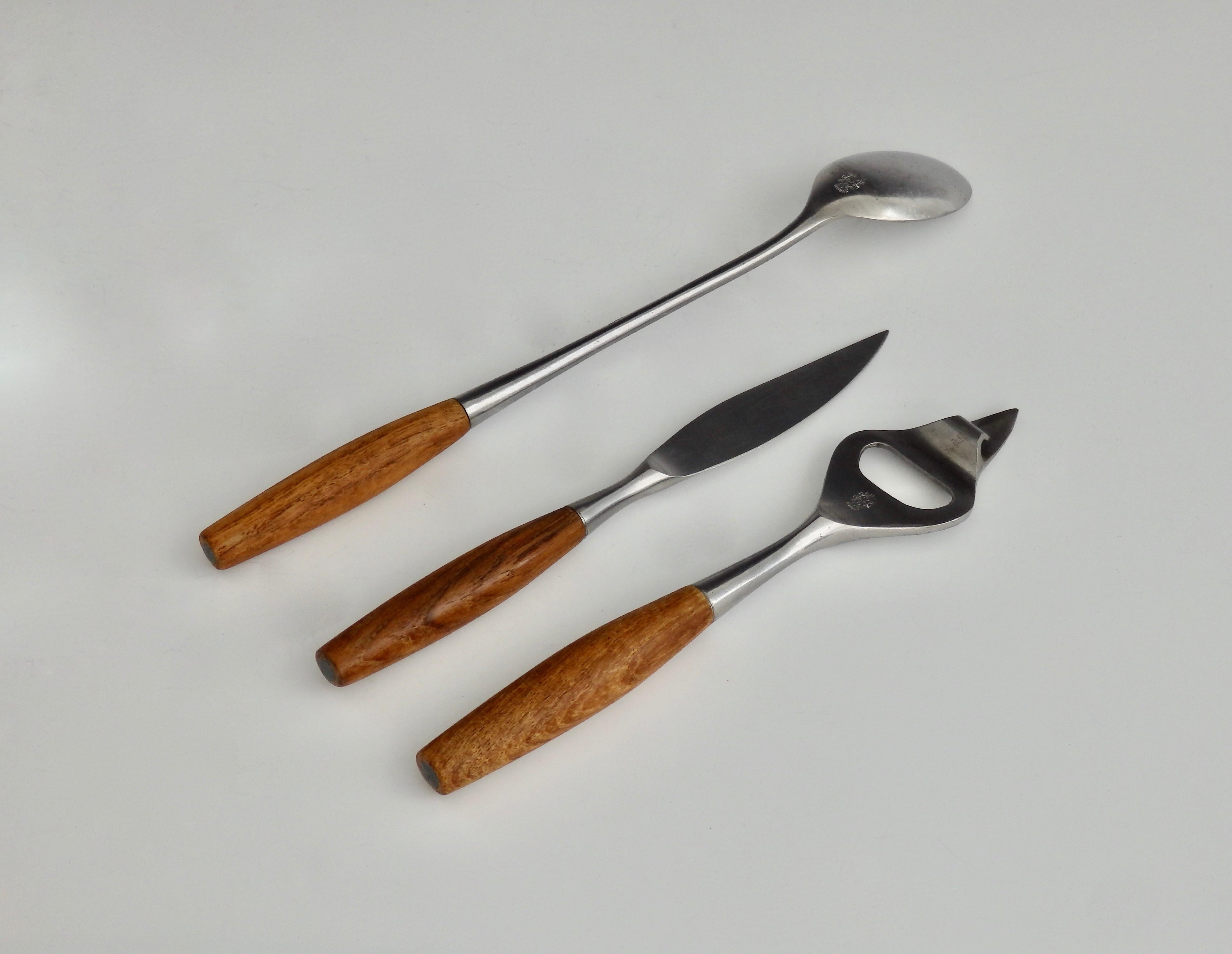 Teak handled three-piece stainless steel bar set. Bottle / can opener, stirring spoon, fruit knife. Marked with Dansk early three duck logo JHQ. Very nice condition.