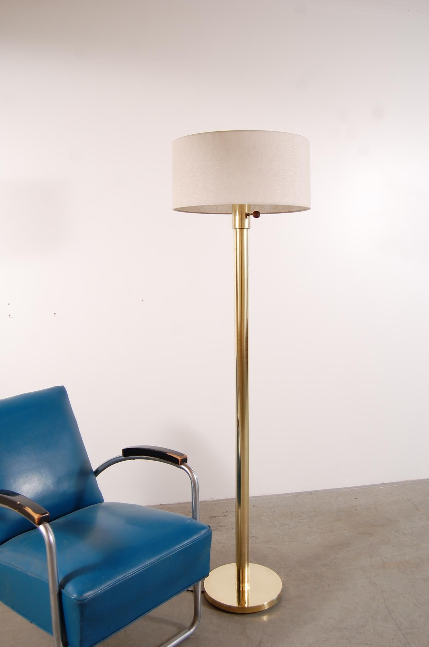 Kurt Versen floor lamp in brass, circa 1938. Lamp has been completely rewired for safety, new cloth wrapped twist cord added, and 3-way switch re-built. New linen shade. Lamp measures 63 1/2