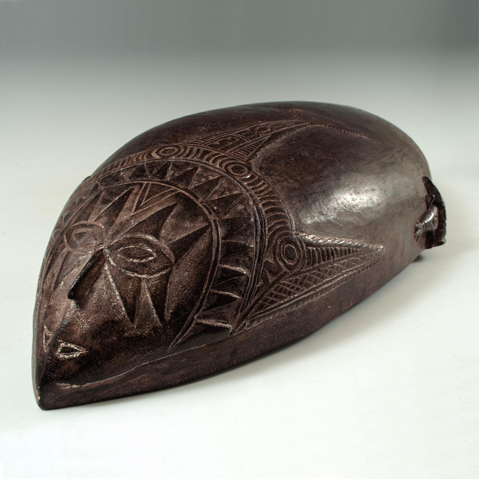Early Large Food Bowl, Tami Islands, Huon Gulf, Papua New Guinea

This large food bowl exhibits a pleasing asymmetry in the raised relief carving of the two spirit faces at either end, both of which feature sharply pointed noses. The walls of the